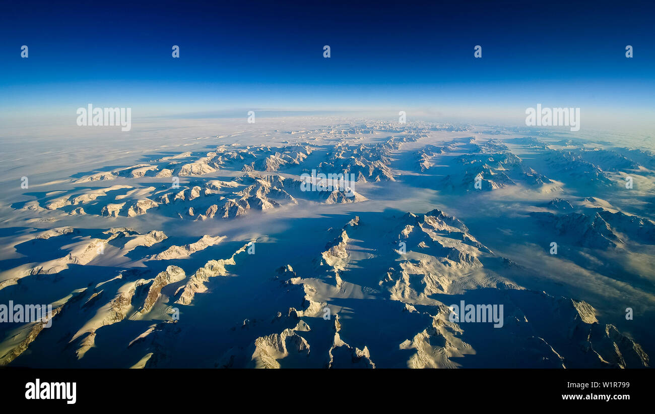 La posizione bassa del sole corsi ombre lunghe al eastfjords della Groenlandia Foto Stock