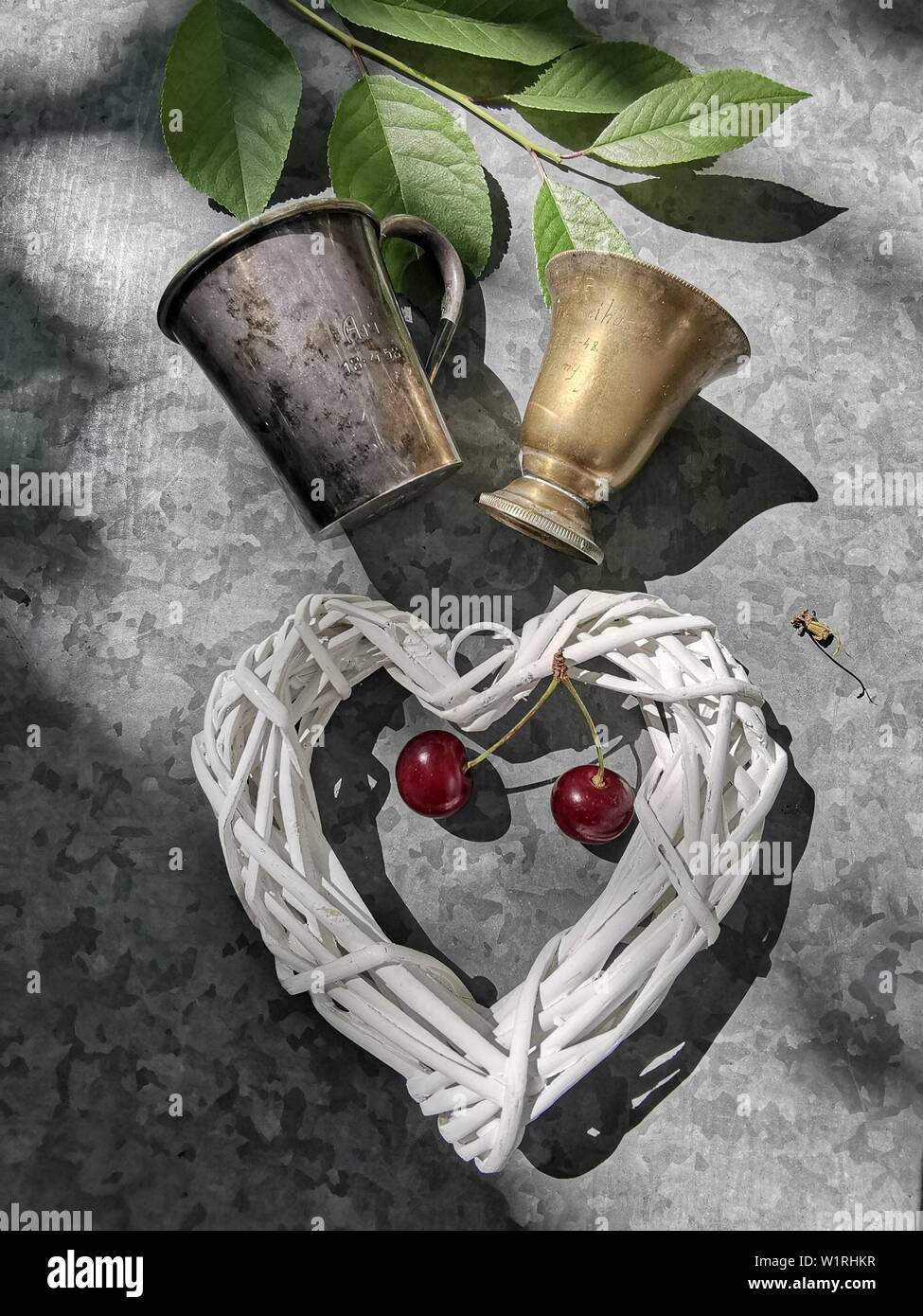 Immagine romantica del cuore e vetro di rame con una ciliegia Foto Stock
