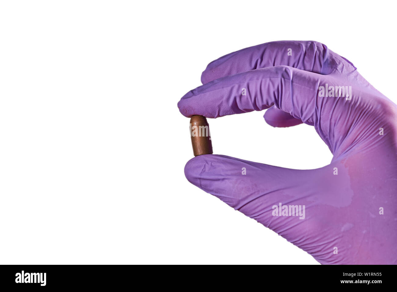 La mano di un uomo in un guanto tenendo un bullet shell. Foto Stock