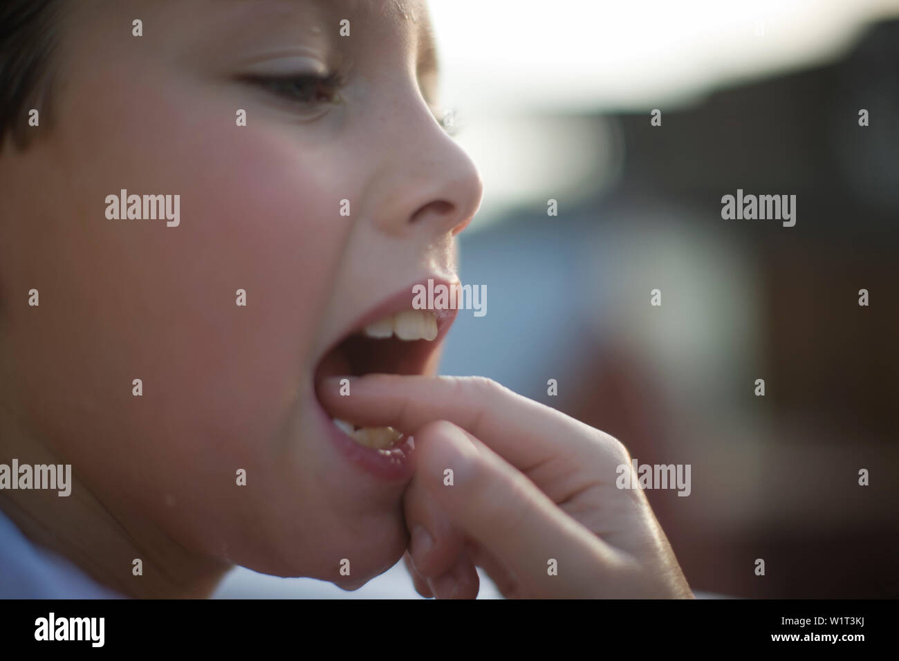 Ragazzo la verifica di un dente allentato Foto Stock