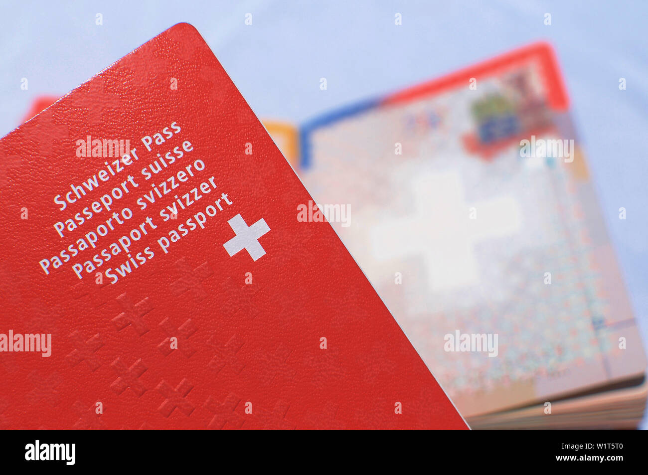 Vista ravvicinata di un passaporto svizzero con una offuscata aprire passaporto svizzero sullo sfondo Foto Stock