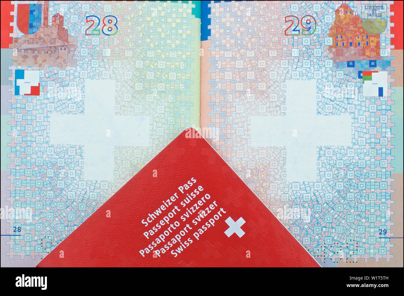 Vista ravvicinata di un passaporto svizzero di cui sopra un altro passaporto aperto in background Foto Stock