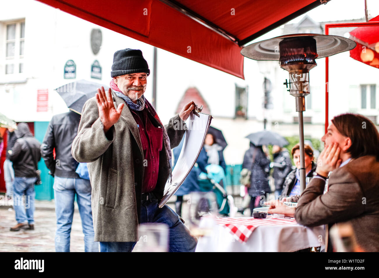Artista di strada a parlare di un turista a La Mère Catherine ristorante, Place du Tertre, Montmartre, Parigi, Francia, Europa Foto Stock