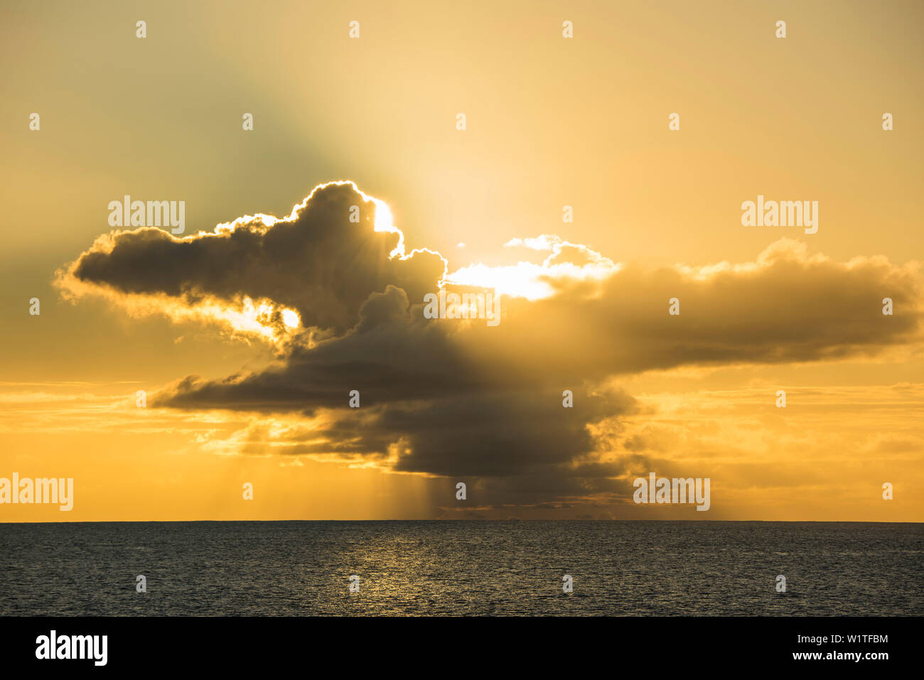 Sole del tardo pomeriggio si rompe attraverso teste di tuono, creando un ambiente caldo e arancio-giallo luce, Bora Bora, Isole della Società, Polinesia francese, Sud Pacifico Foto Stock