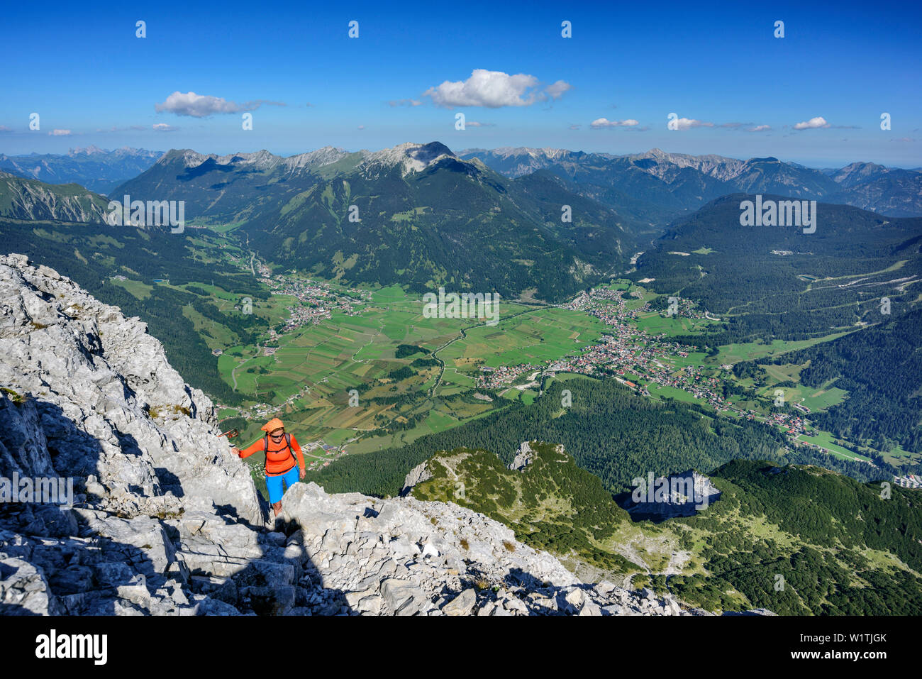 Donna escursionismo verso Ehrwalder Sonnenspitze, Lermoos Ehrwald e Alpi Ammergau in background, Ehrwalder Sonnenspitze, gamma di Mieming, Tirolo, Austria Foto Stock