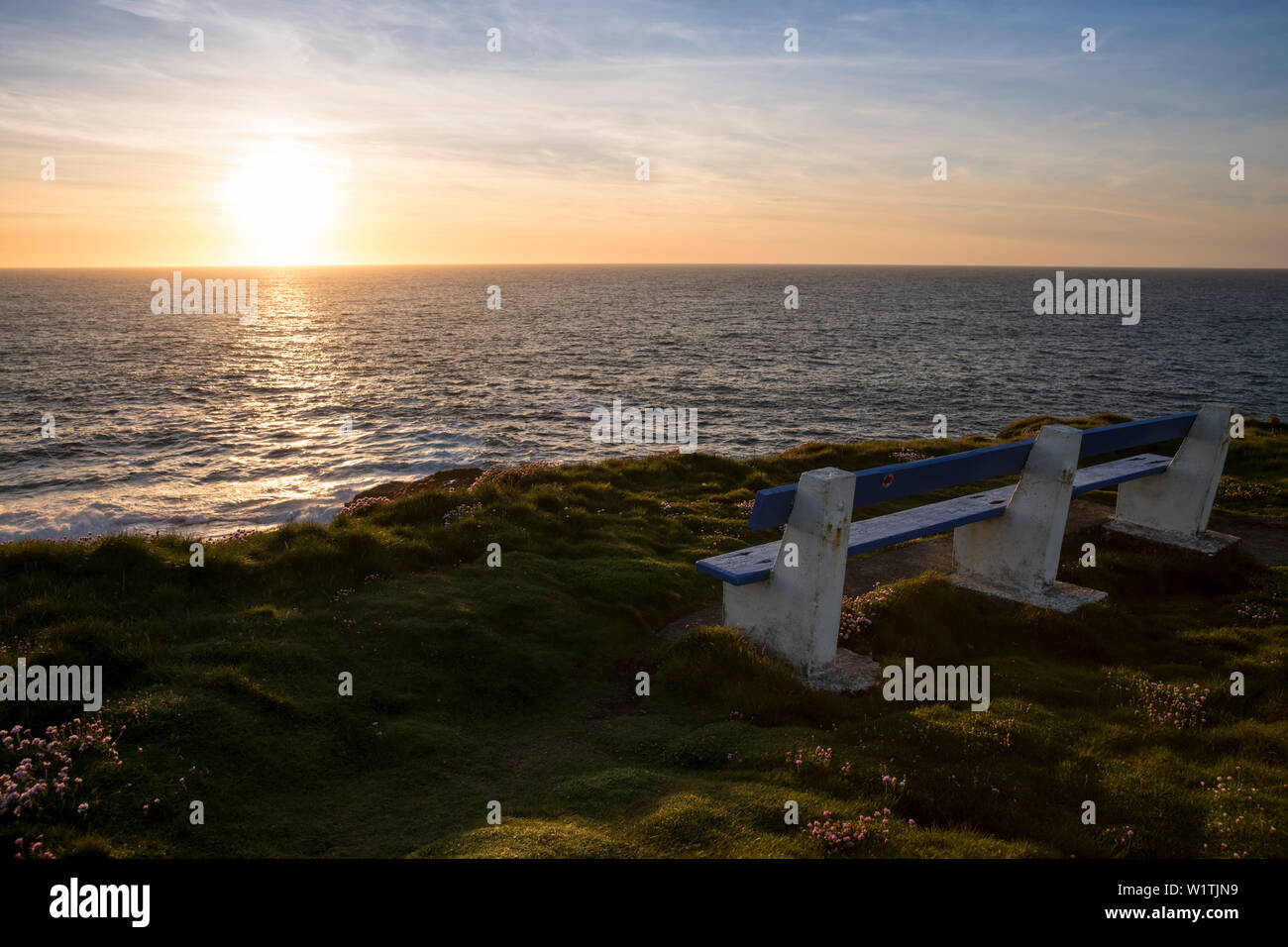 Una panchina nel parco per godersi il tramonto sopra le scogliere di Kilkee e l'Oceano Atlantico, Kilkee, County Clare, Irlanda, Europa Foto Stock