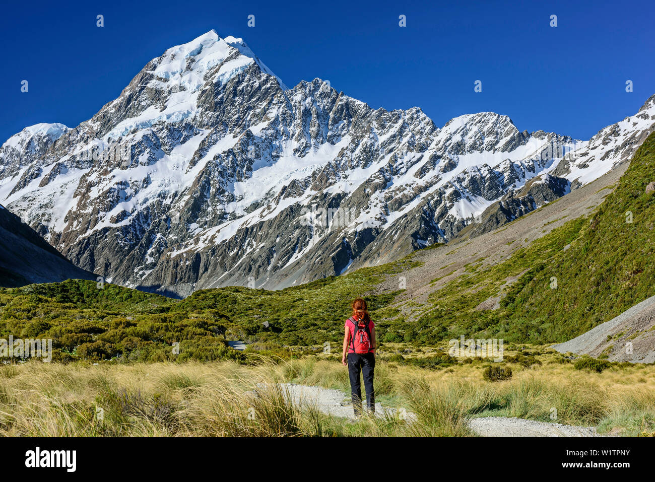 Donna escursioni attraverso Hooker valley, Mount Cook in background, Hooker Valley, il Parco nazionale di Mount Cook, UNESCO Welterbe Te Wahipounamu, Lago Pukaki, Ca Foto Stock
