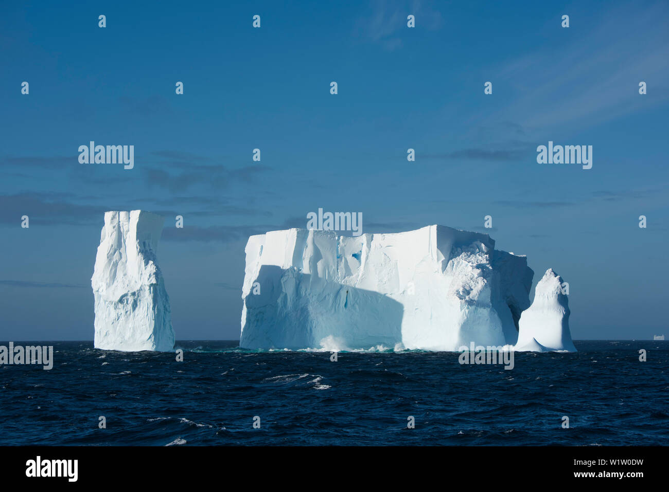 Un iceberg, una volta molto più grandi, ma ora è dotato di tre torri, galleggianti in mare aperto, vicino a sud delle Isole Shetland, Antartide Foto Stock