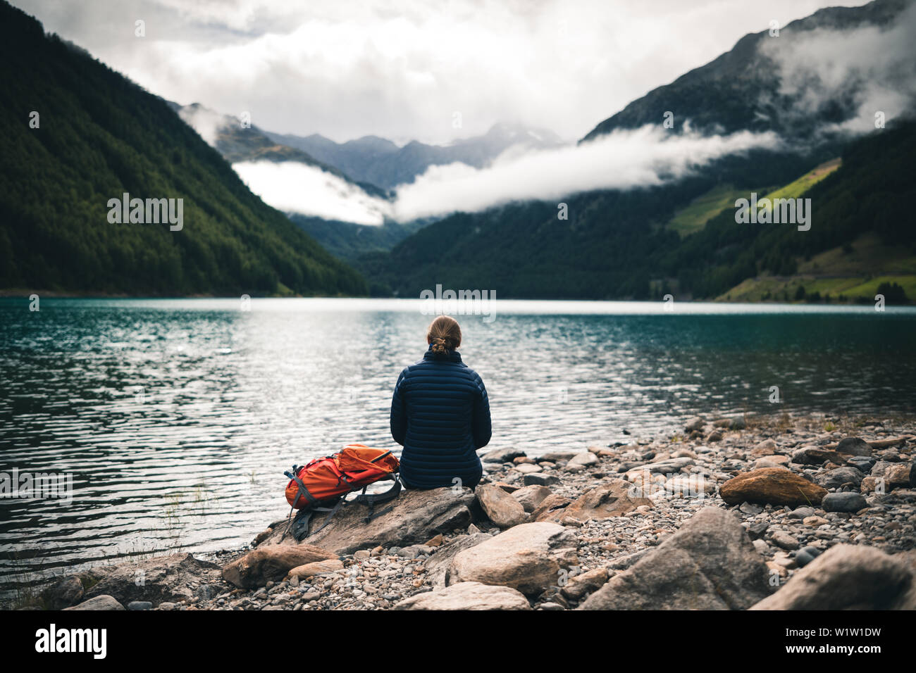 Scalatore gode di vista sul serbatoio di Vernago in misty umore, E5, Alpenüberquerung, 6a tappa, sfiato,Niederjochbach, rifugio Similaun, Val Senales, Vernago ri Foto Stock