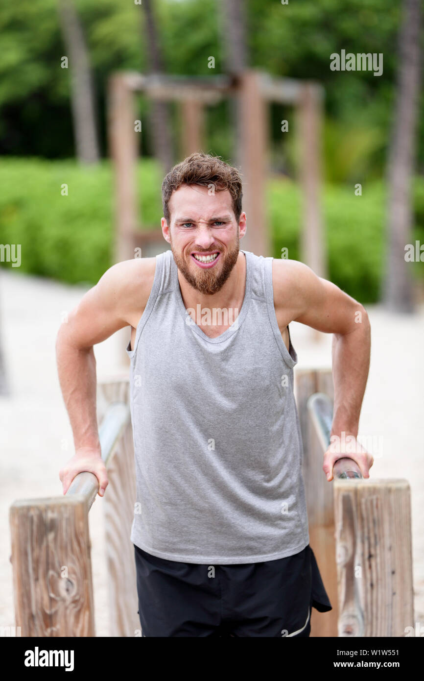 L'uomo facendo forza difficile esercizi di formazione - fitness cardio allenamento. Giovani caucasici atleta maschio lavoro duro sulla giungla esterna Palestra / Monkey bar sulla spiaggia di estate Foto Stock