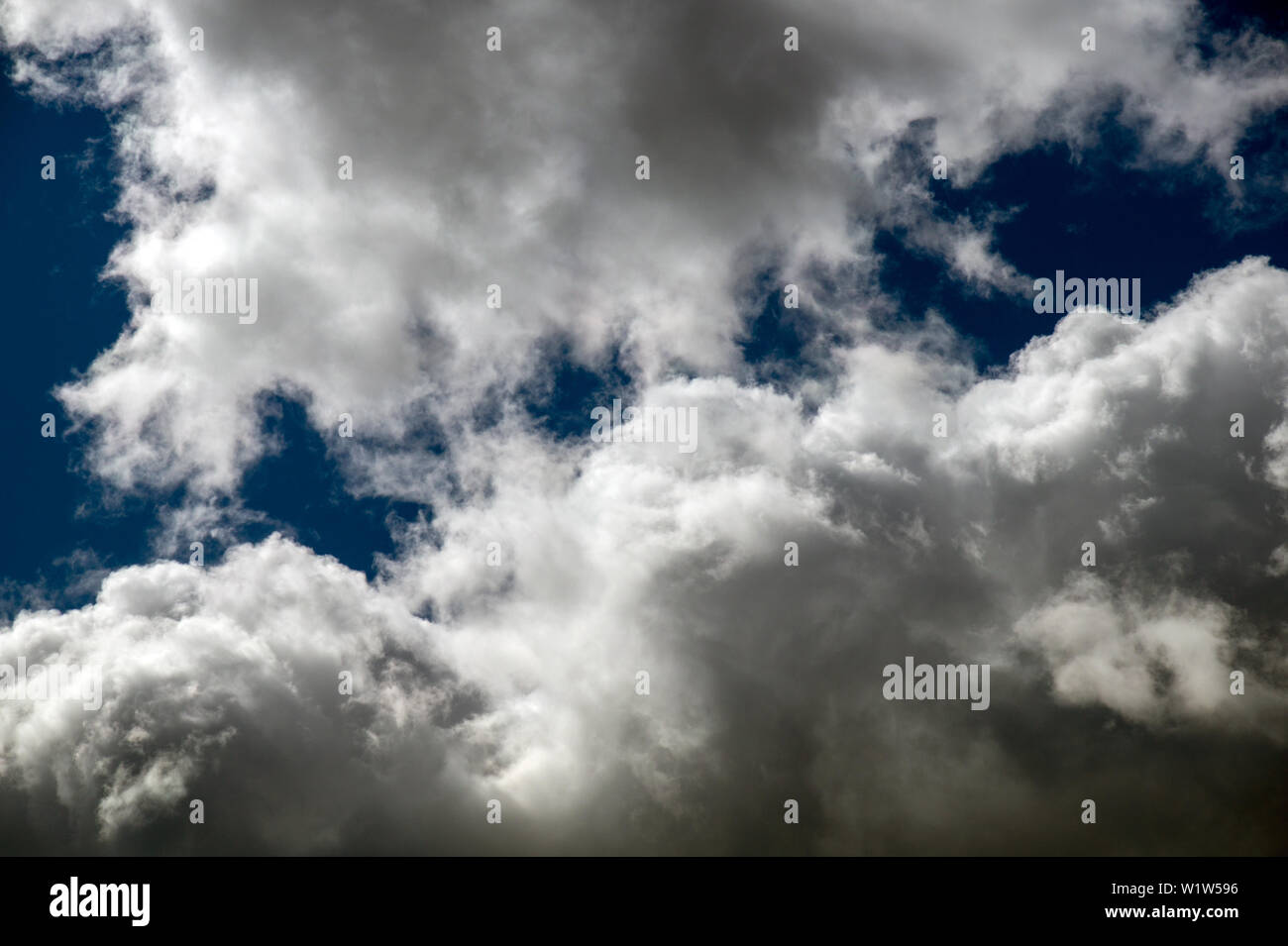 Pioggia nuvole nel cielo blu su una soleggiata giornata estiva Foto Stock