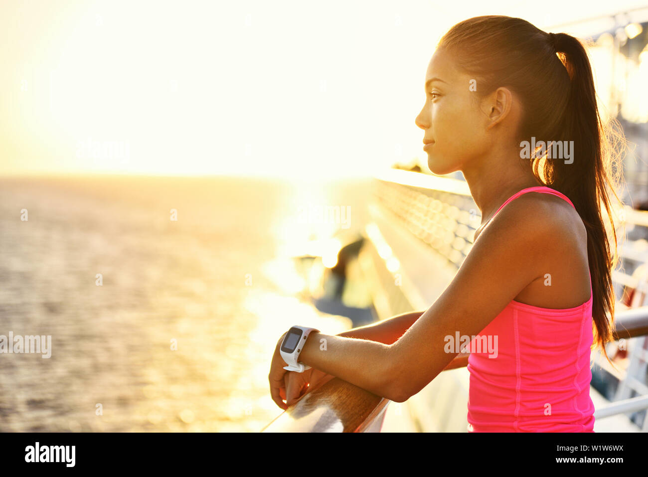 Donna attiva rilassante dopo aver eseguito su una nave da crociera guardando il mare durante le vacanze estive. Asiatica ragazza runner indossa smartwatch frequenza cardiaca monitor attività di vivere uno stile di vita sano. Foto Stock