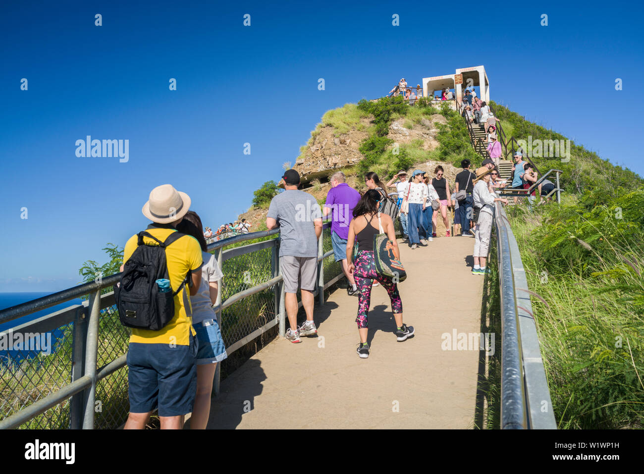 I turisti escursione alla parte superiore della testa di diamante a vedere il vecchio bunker di artiglieria di vista di Waikiki. Foto Stock