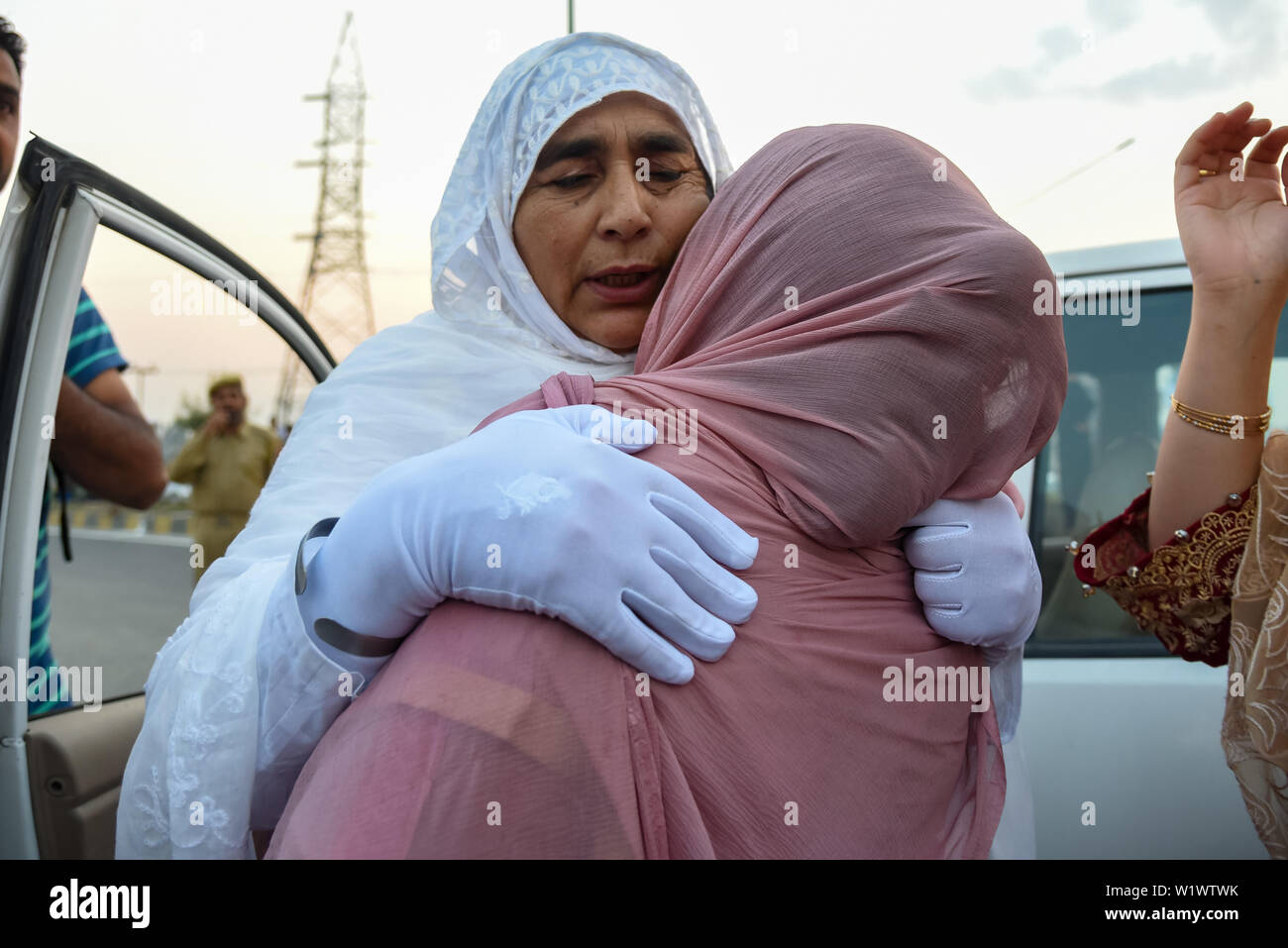 Srinagar, India. 04 Luglio, 2019. Un musulmano del Kashmir pellegrino viene abbracciato dalla sua parente prima della partenza delle annuali hajj pellegrinaggio alla Mecca in Srinagar.Il primo lotto di 304 musulmani del Kashmir hajj pellegrini verso sinistra per l'annuale pellegrinaggio alla Mecca, in Arabia Saudita, il luogo sacro per i musulmani. Credito: SOPA Immagini limitata/Alamy Live News Foto Stock