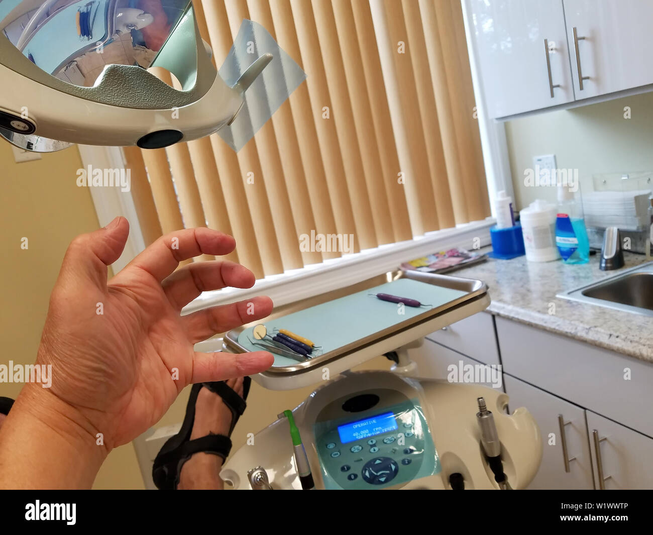 Un leggermente terrorizzato il paziente sta andando attraverso la temuta dente il processo di perforazione. Foto Stock