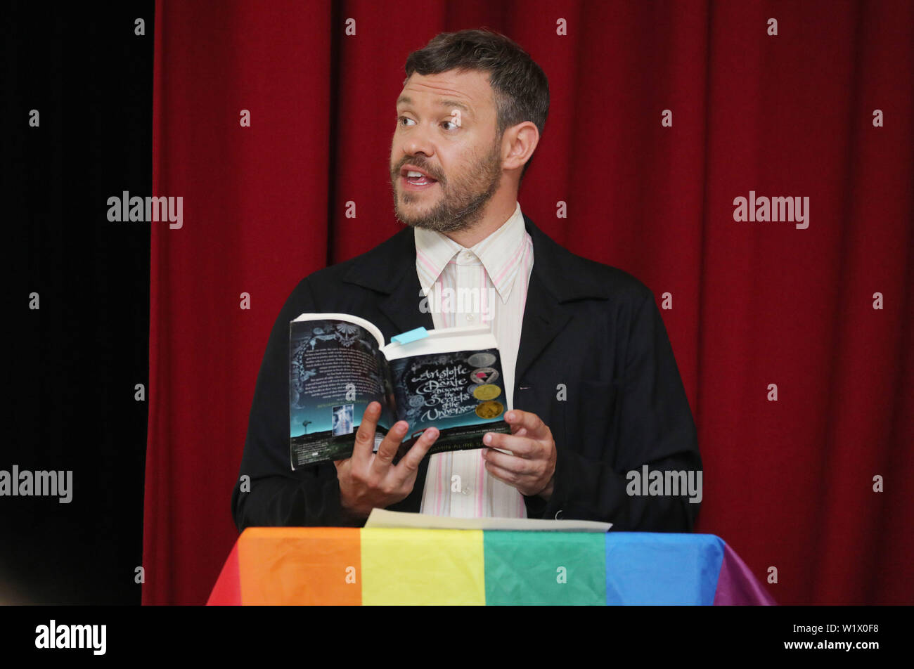 Music artista giovane legge un libro per gli alunni a Petchey Academy durante il lancio dell'amazzonia LGBT+ Roadshow di lettura per un workshop speciale su LGBT+ diversità e di inclusività. Foto Stock