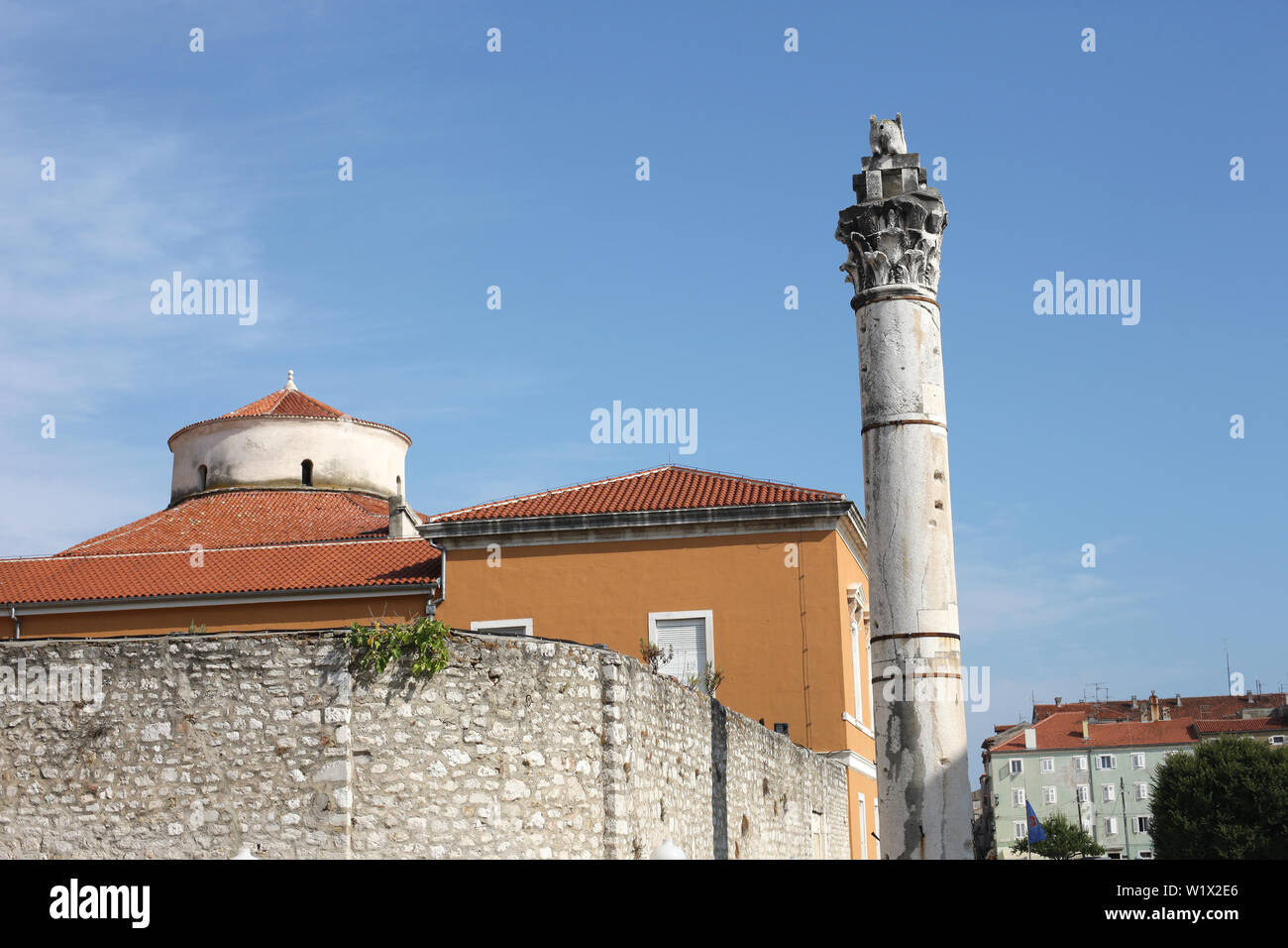 Una vecchia colonna vicino a un alto muro di pietra. Croazia, Zadar Foto Stock