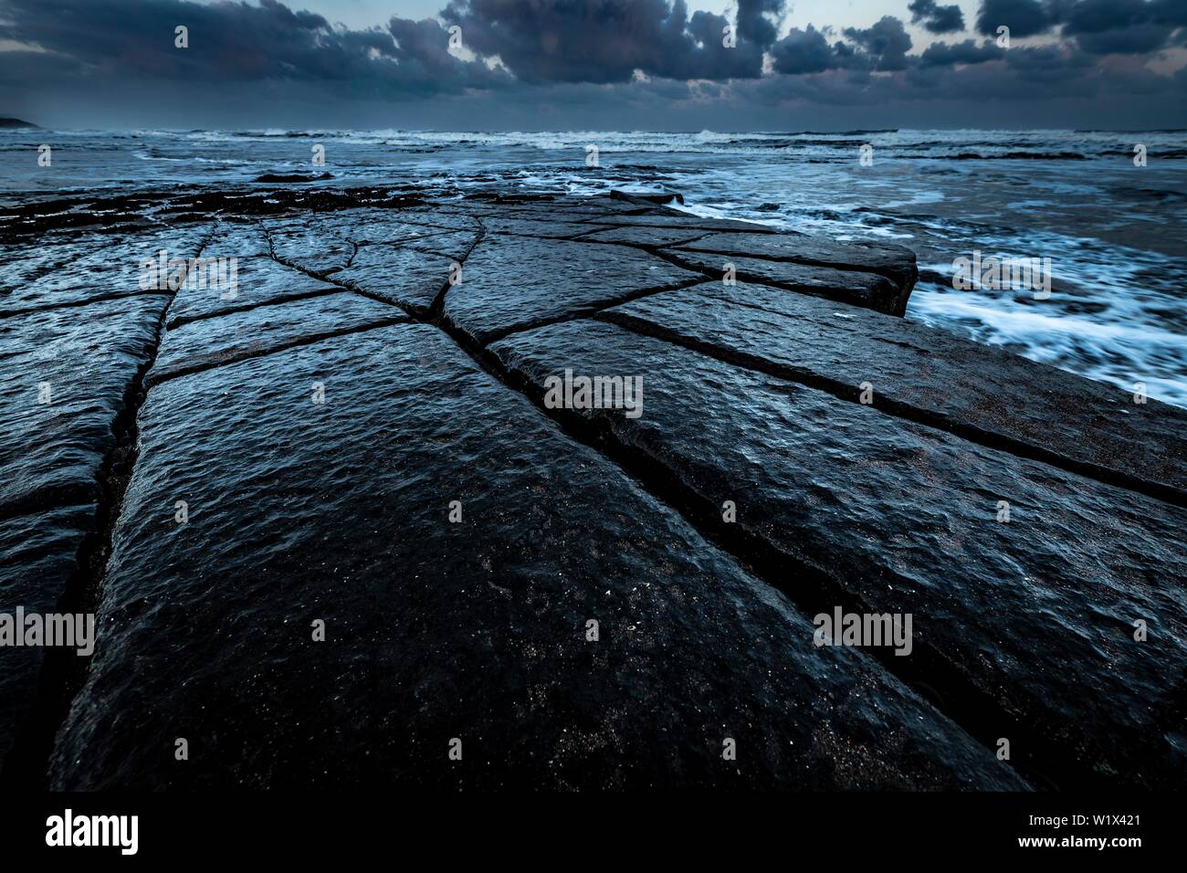 Costa con rocce granitiche bagnata dal mare nella luce della sera, Berwick fino On Tweed, Northumberland, Gran Bretagna Foto Stock