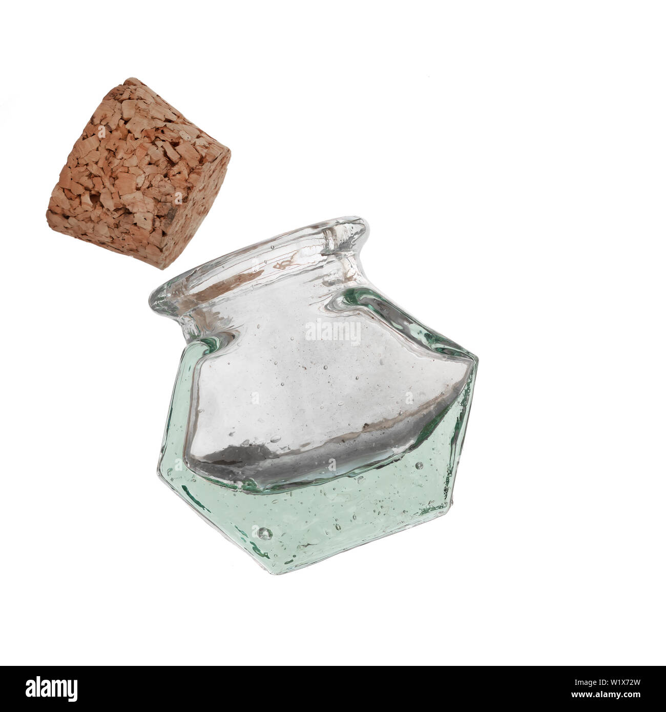 Vecchio vasetto in vetro o pentola, verde fatta a mano con bolle, tappo di sughero, isolato su bianco. Per le erbe aromatiche, le spezie. Insolita forma esagonale. Foto Stock
