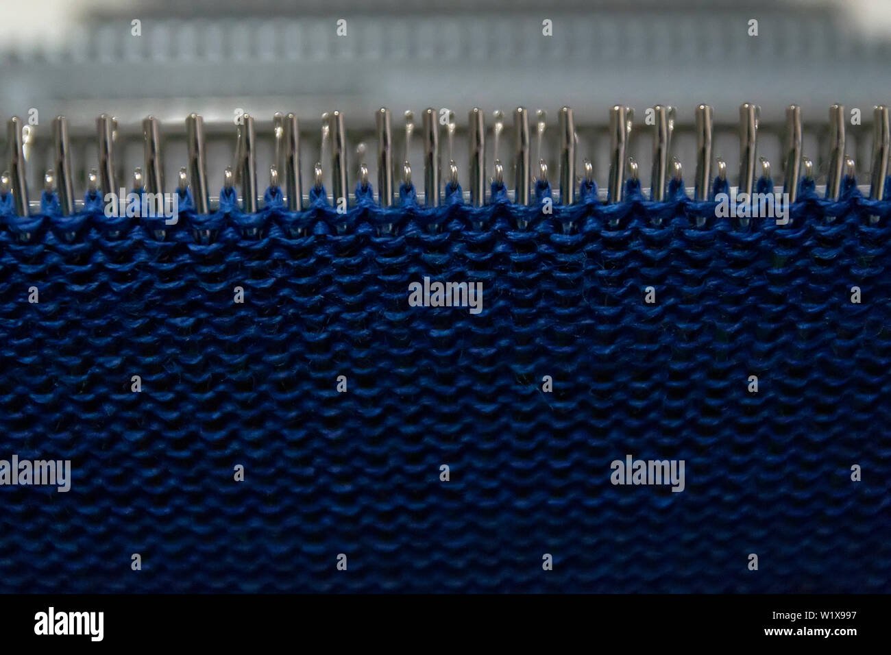 Manuale della macchina di lavorazione a maglia. Una macchina di lavorazione a maglia è un dispositivo utilizzato per creare tessuti a maglia. Foto Stock