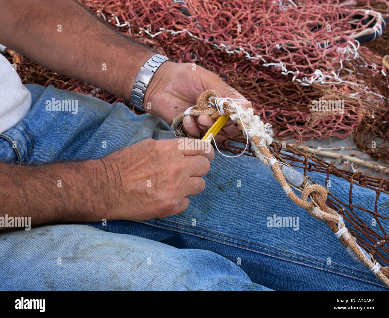 Fisherman rammendo la sua rete da pesca. Primo piano dettaglio. Foto Stock