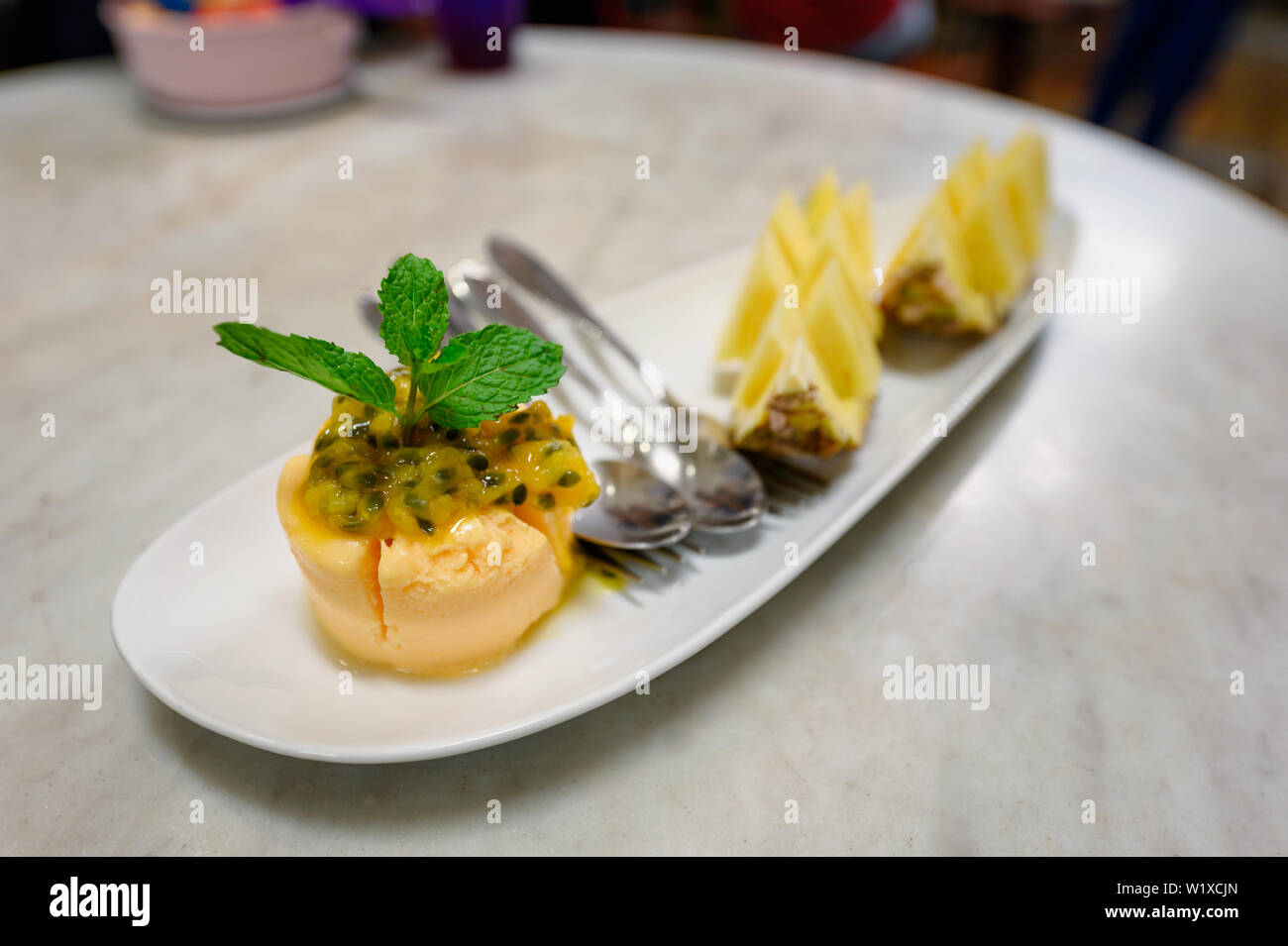 Il gelato al frutto della passione sorbetto con fette di frutta sulla piastra Foto Stock