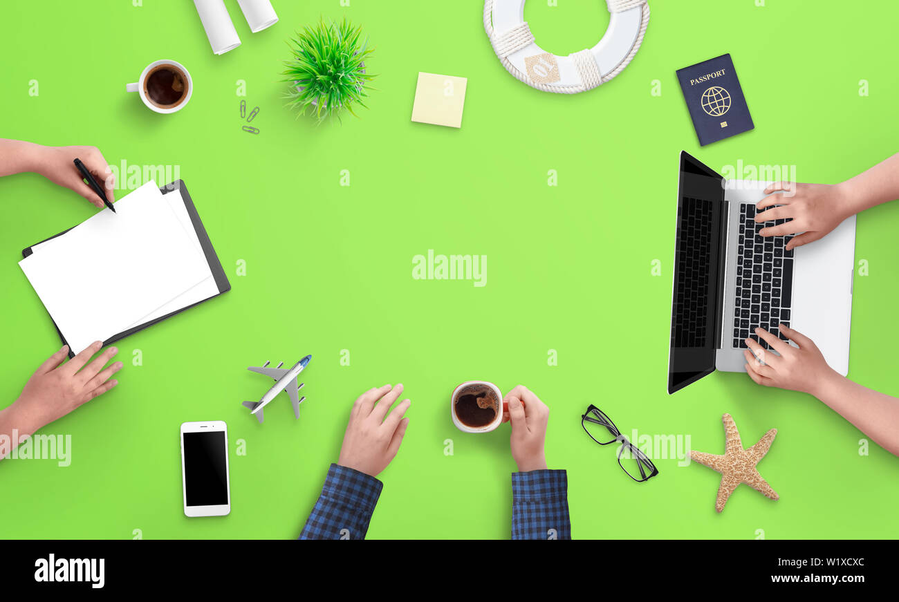 Pianificazione del concetto di viaggio. Le persone lavorano su computer e documenti. Vista superiore del green office desk, piatto laici. Copia spazio in mezzo per il testo. Foto Stock