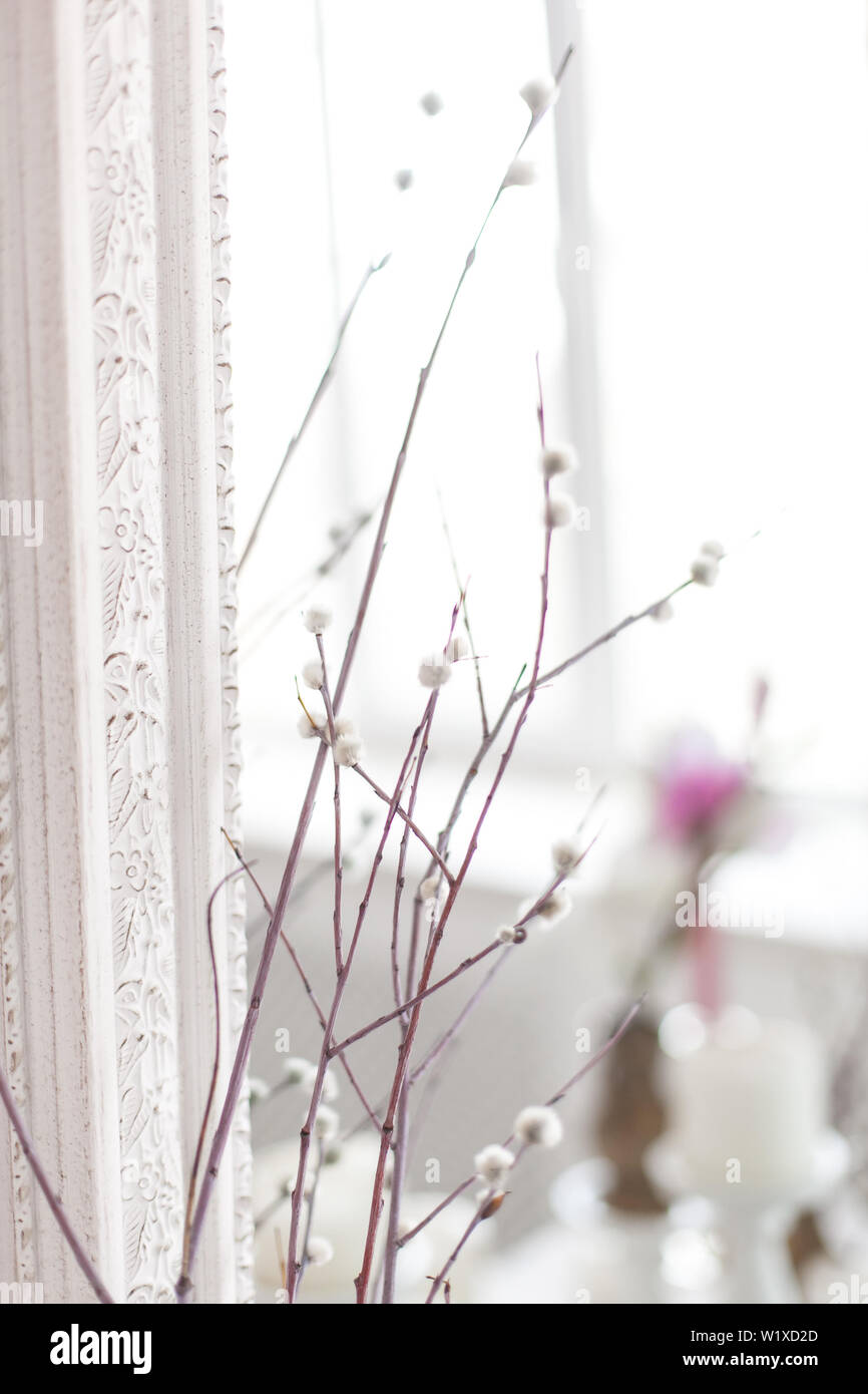 Vintage interno con uno specchio antico e un tavolo con un vaso e salici. Soft focus. Foto Stock