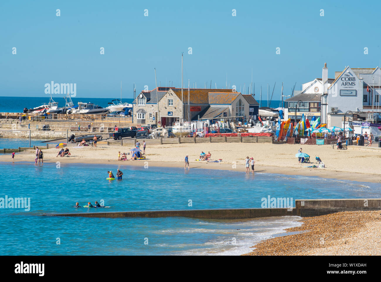 Lyme Regis, Dorset, Regno Unito. 4 luglio 2019. Meteo REGNO UNITO: caldo sole e cieli blu alla stazione balneare di Lyme Regis. Inizio beachgoers fissare una macchia sulla bella spiaggia di sabbia a Lyme Regis giovedì mattina. Credito: Celia McMahon/Alamy Live News. Foto Stock