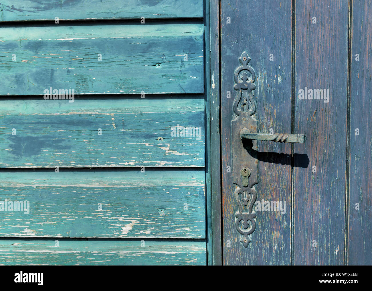 Chiudere il bloccaggio maniglia di un azzurro porta in legno blu sulla parete in legno Foto Stock