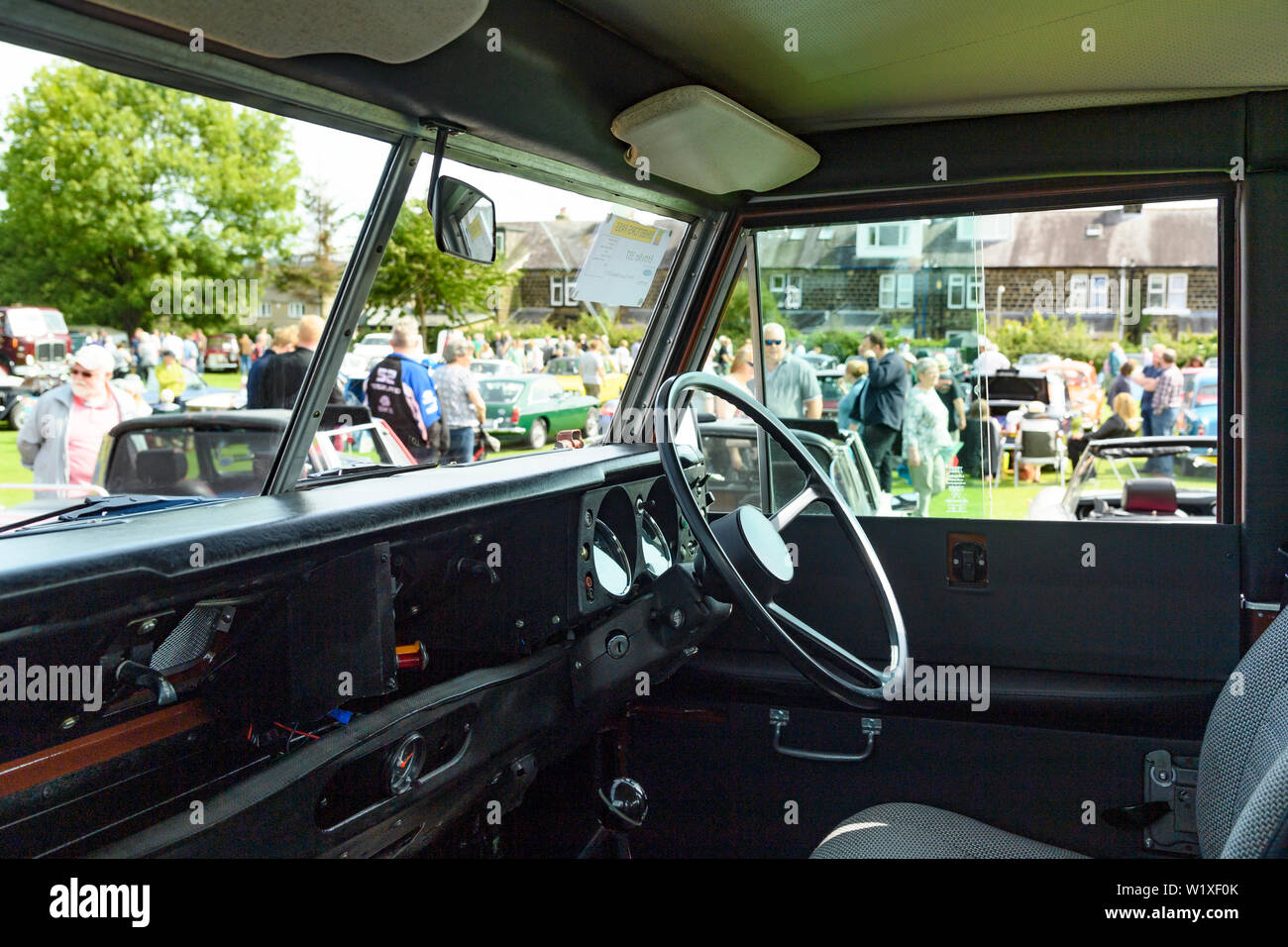 Vista interna della leggendaria Land Rover (1982 Series 3 County Station Wagon) & i visitatori al classico spettacolo del veicolo al di là - Burley in Wharfedale, Inghilterra, Regno Unito. Foto Stock