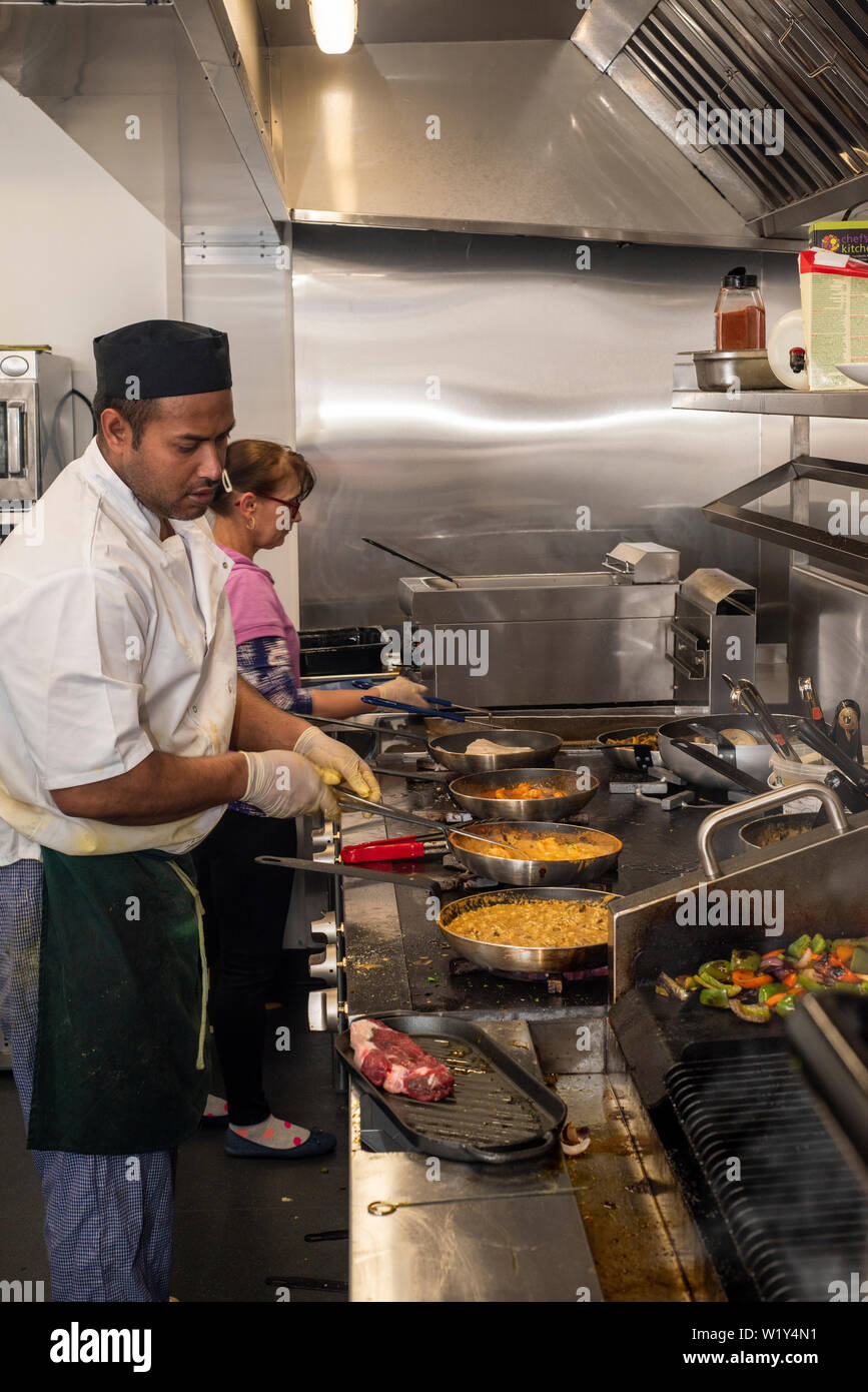 Doncaster, Regno Unito - 11 Maggio 2019: i due chef in un duro lavoro per la cottura di un occupato Sabato notte servizio cena su 11 Maggio a La Boca bisteccheria argentina ristorante Foto Stock