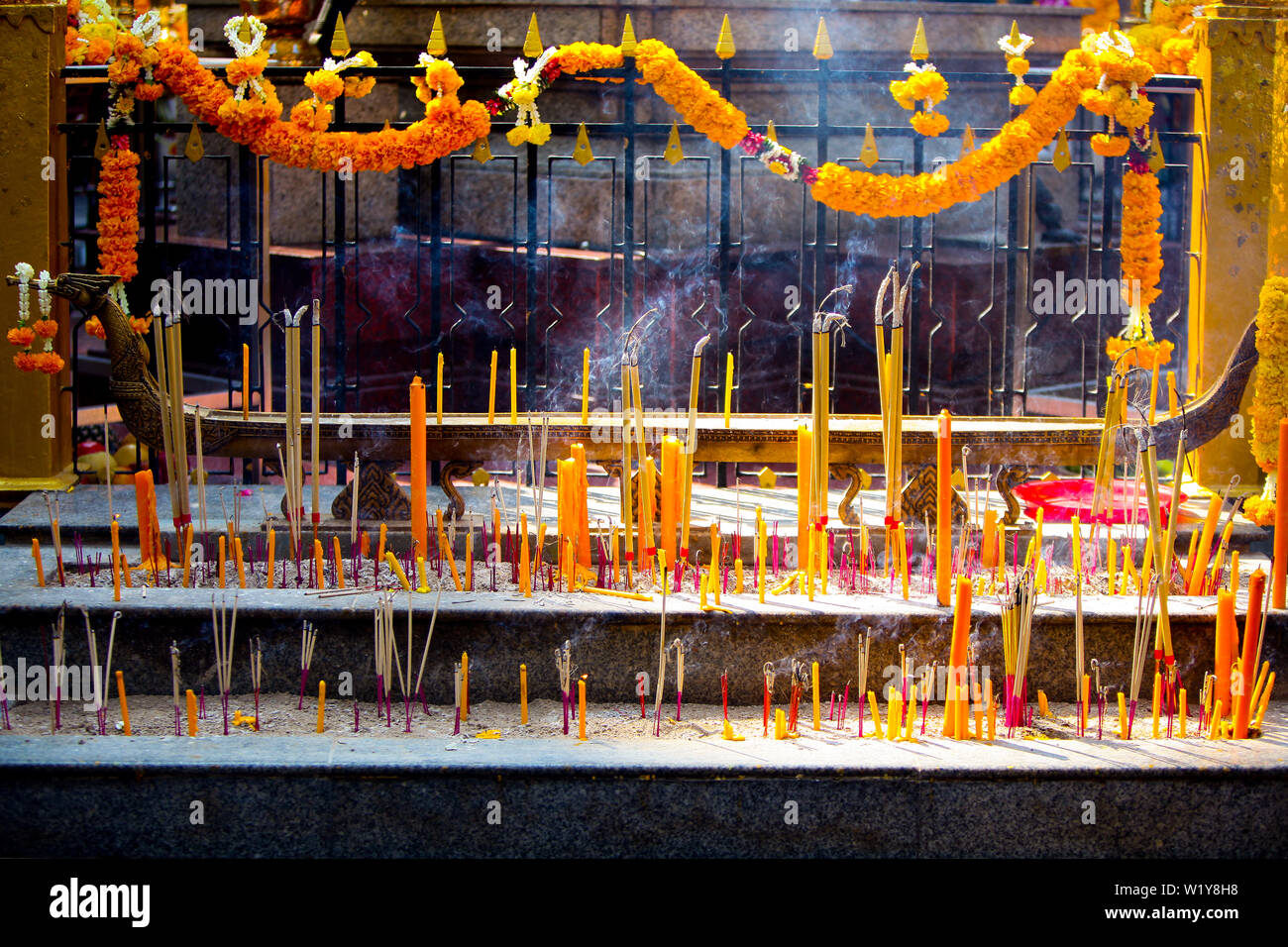Brucia Incenso, candele giallo e calendula fiori sulla scalinata del Santuario di Erawan accanto al Grand Hyatt Erawan Hotel all'intersezione di ratto Foto Stock