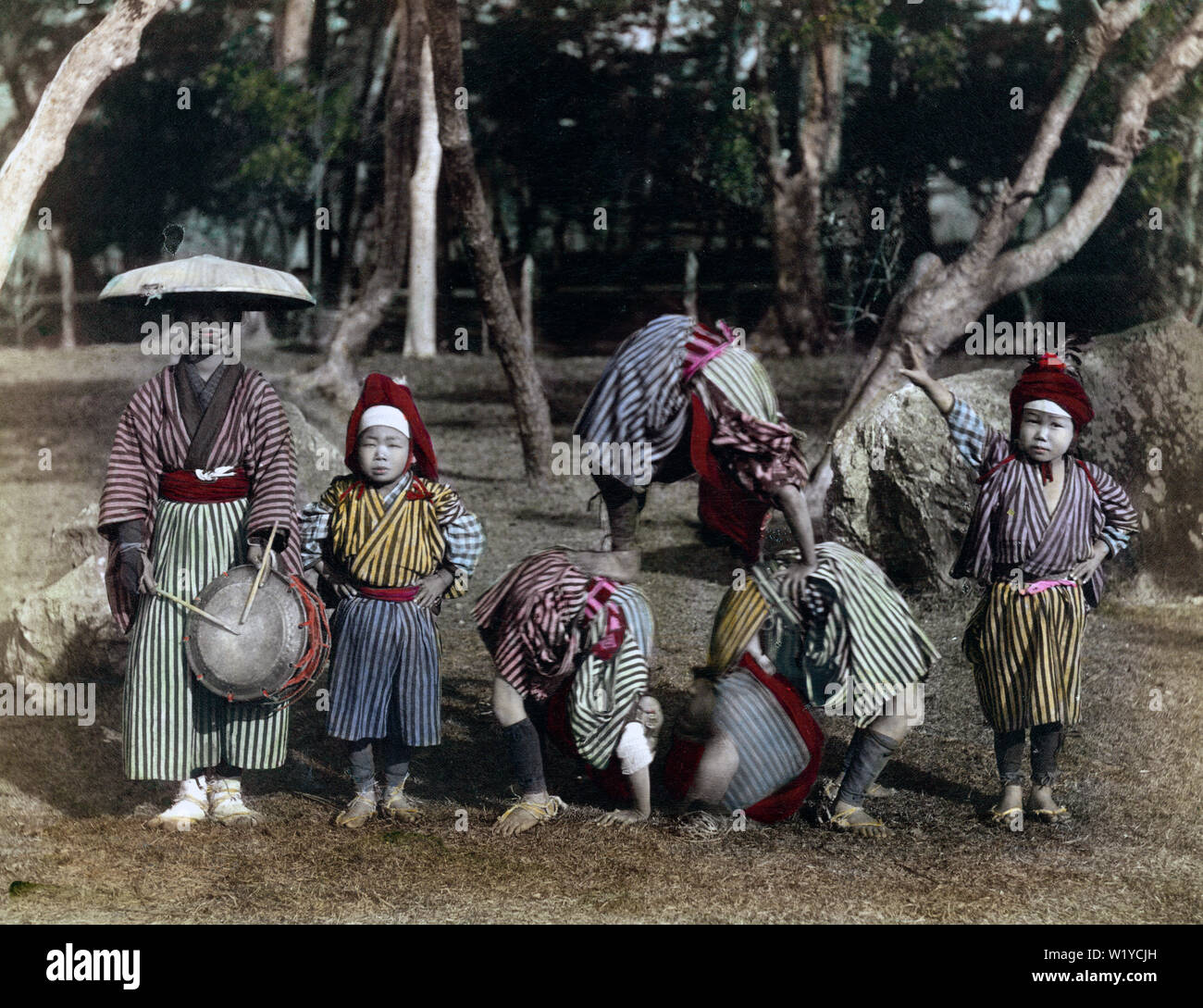 [ 1890 Giappone - Kakubeijishi acrobati ] - Kakubeijishi (anche: Kakubeejishi) sono acrobazie eseguite su strada da giovani ragazzi che hanno fatto le verticali, salti mortali e simili, da soli o con i loro partner. In questa foto, tre figli eseguire una combinazione di agire. Le acrobazie sono state accompagnate da tamburi, giocato solitamente da un adulto responsabile. Kakubeijishi ha le sue radici nella provincia di Echigo (ora nella Prefettura di Niigata). Xix secolo albume vintage fotografia. Foto Stock