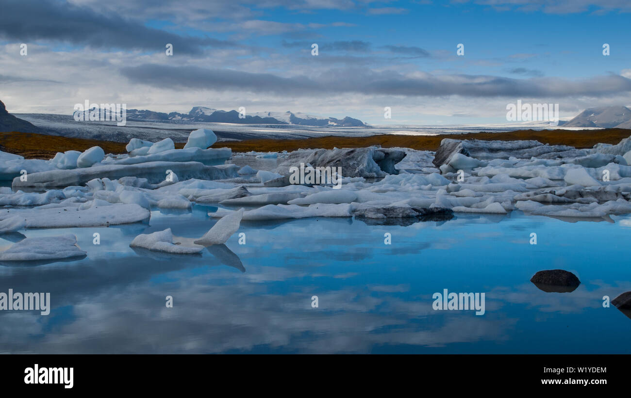 Bellissima vista del Fjallsárlón laguna glaciale, lago blu con iceberg galleggianti dal ghiacciaio nel retro. Foto Stock