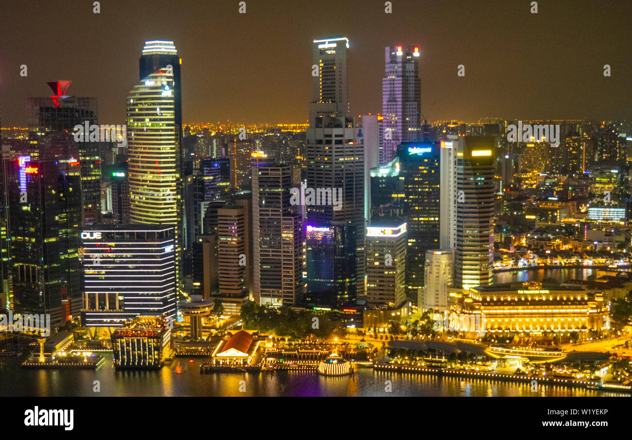 Torri e grattacieli del centro cittadino di Singapore illuminata di notte. Foto Stock