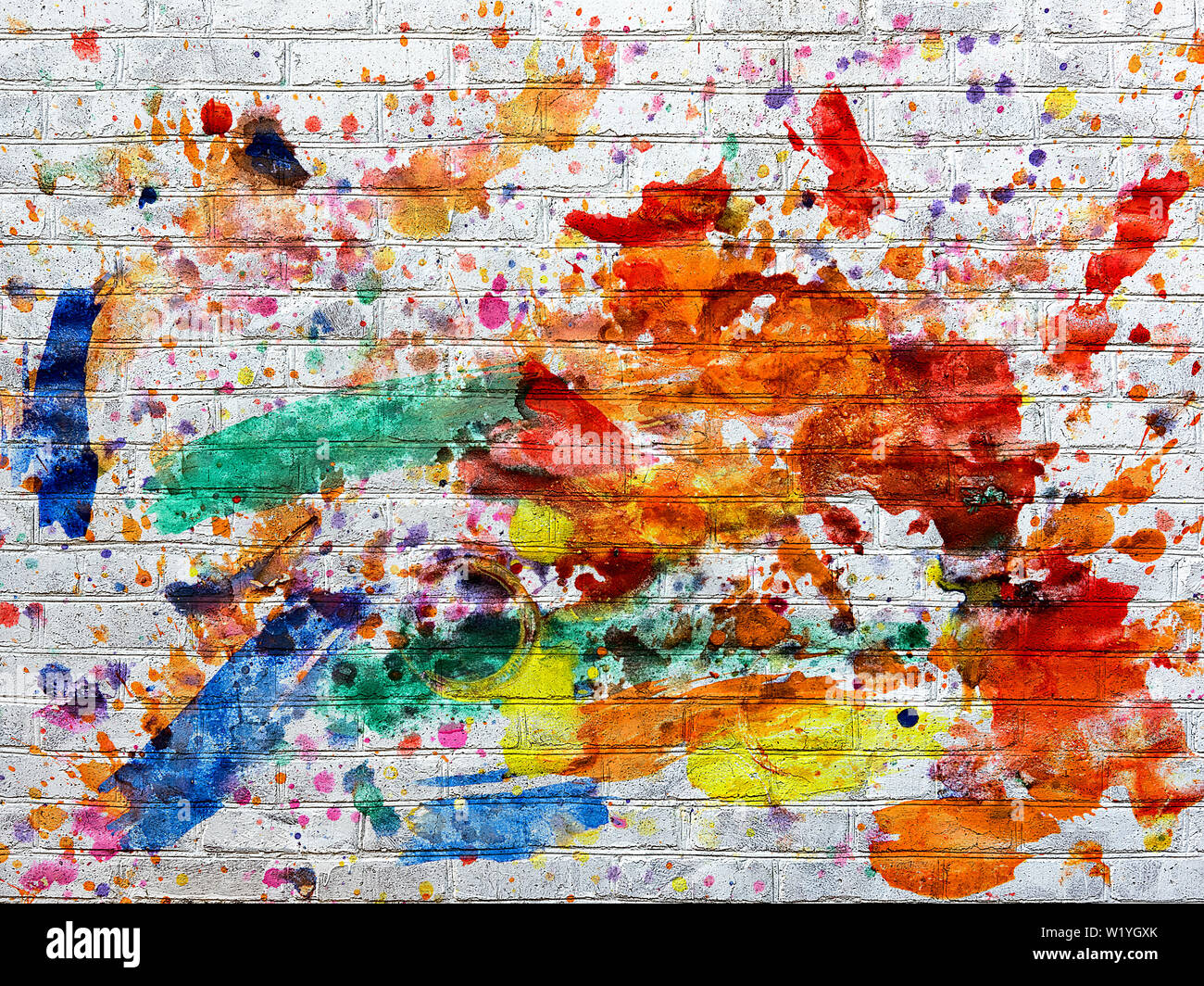 Bianco parete di mattoni macchiati macchie di vernice di diversi colori Foto Stock