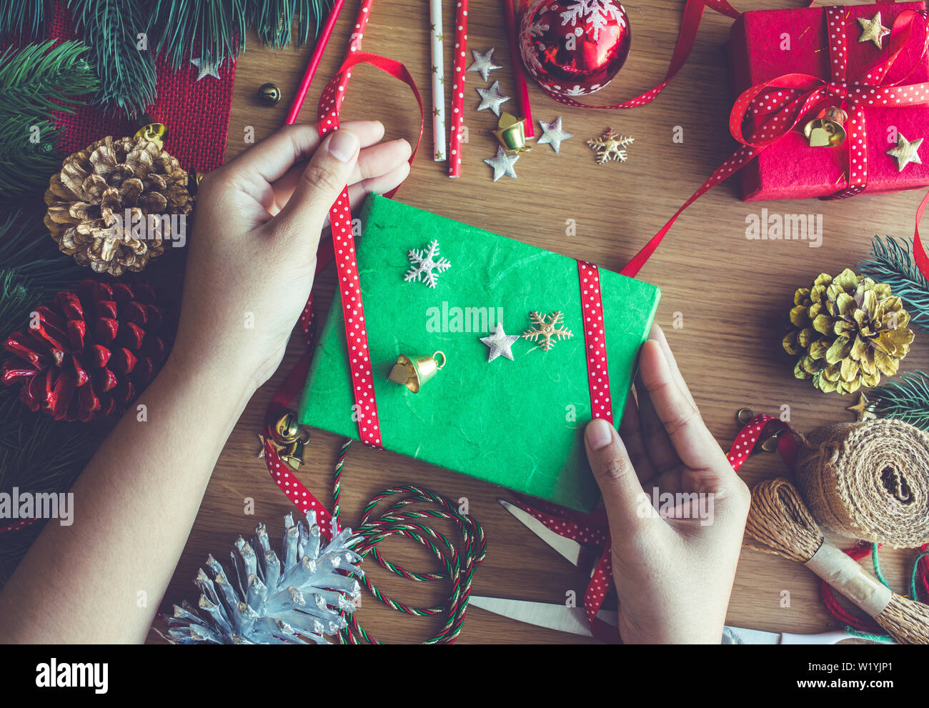 Buon Natale concetti con mano umana decorare confezione regalo presente e elemento di ornamento sulla tavola di legno sfondo.stagione invernale della auguri idee Foto Stock