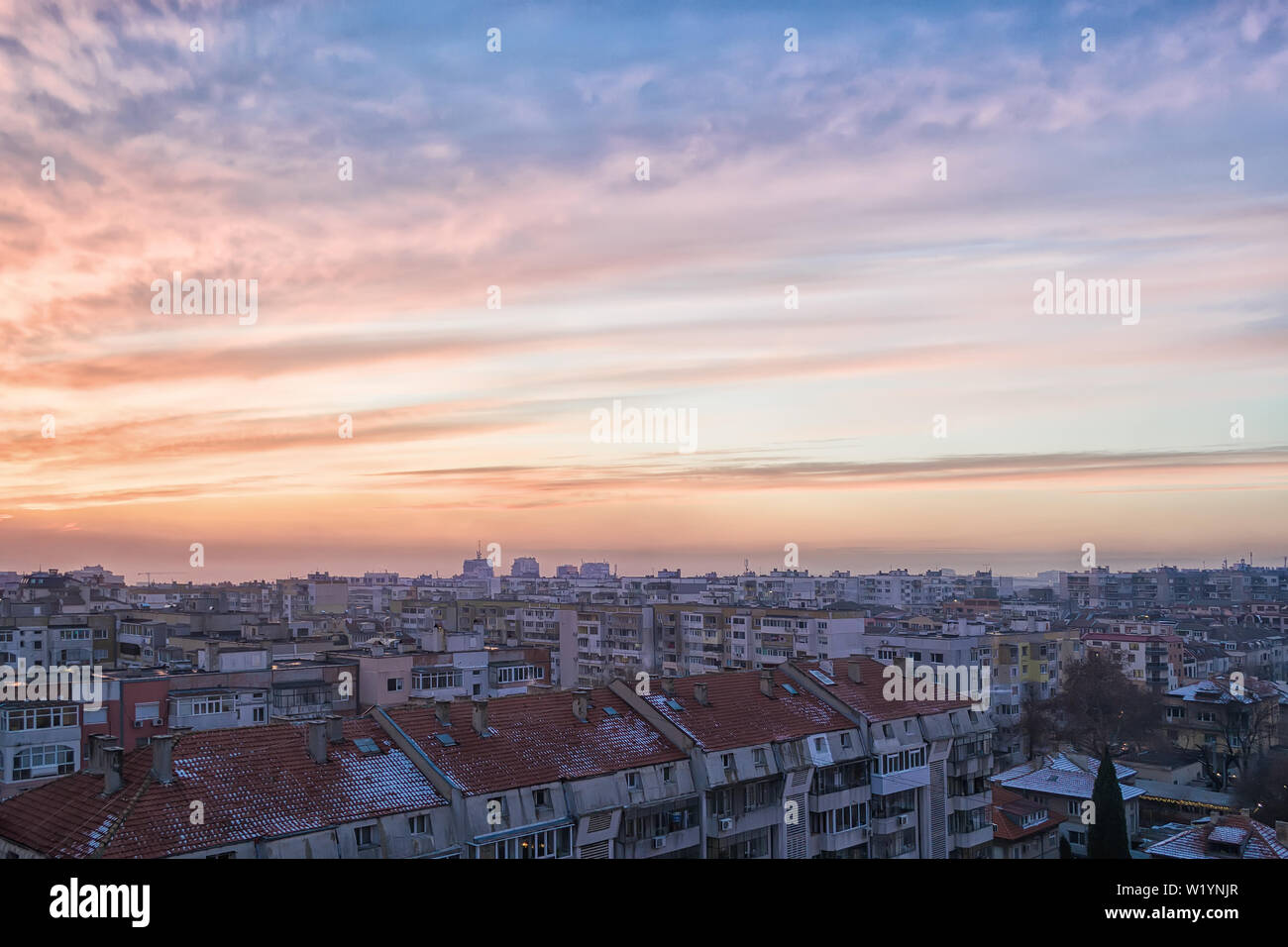 La pittoresca Cielo di tramonto con blu-arancio nuvole. Paesaggio invernale e urban skyline al tramonto del tempo. Vista panoramica della città e del cielo durante il tramonto. Foto Stock