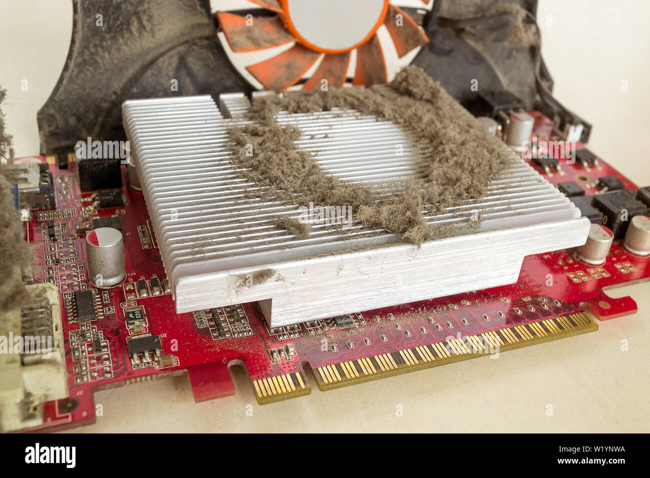 Impolverata scheda grafica esterna al di fuori di un personal computer per la pulizia. Un sacco di polvere sul radiatore di raffreddamento della scheda video processore pc sporca Foto Stock