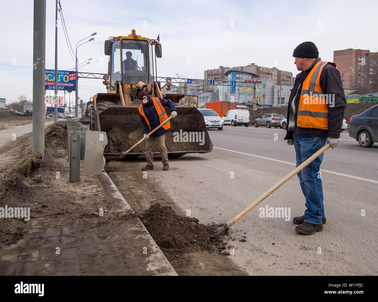Voronezh, Russia - Marzo 15, 2019: Pulizia la sabbia sul lato della strada da parte dei lavoratori del servizio di miglioramento Foto Stock