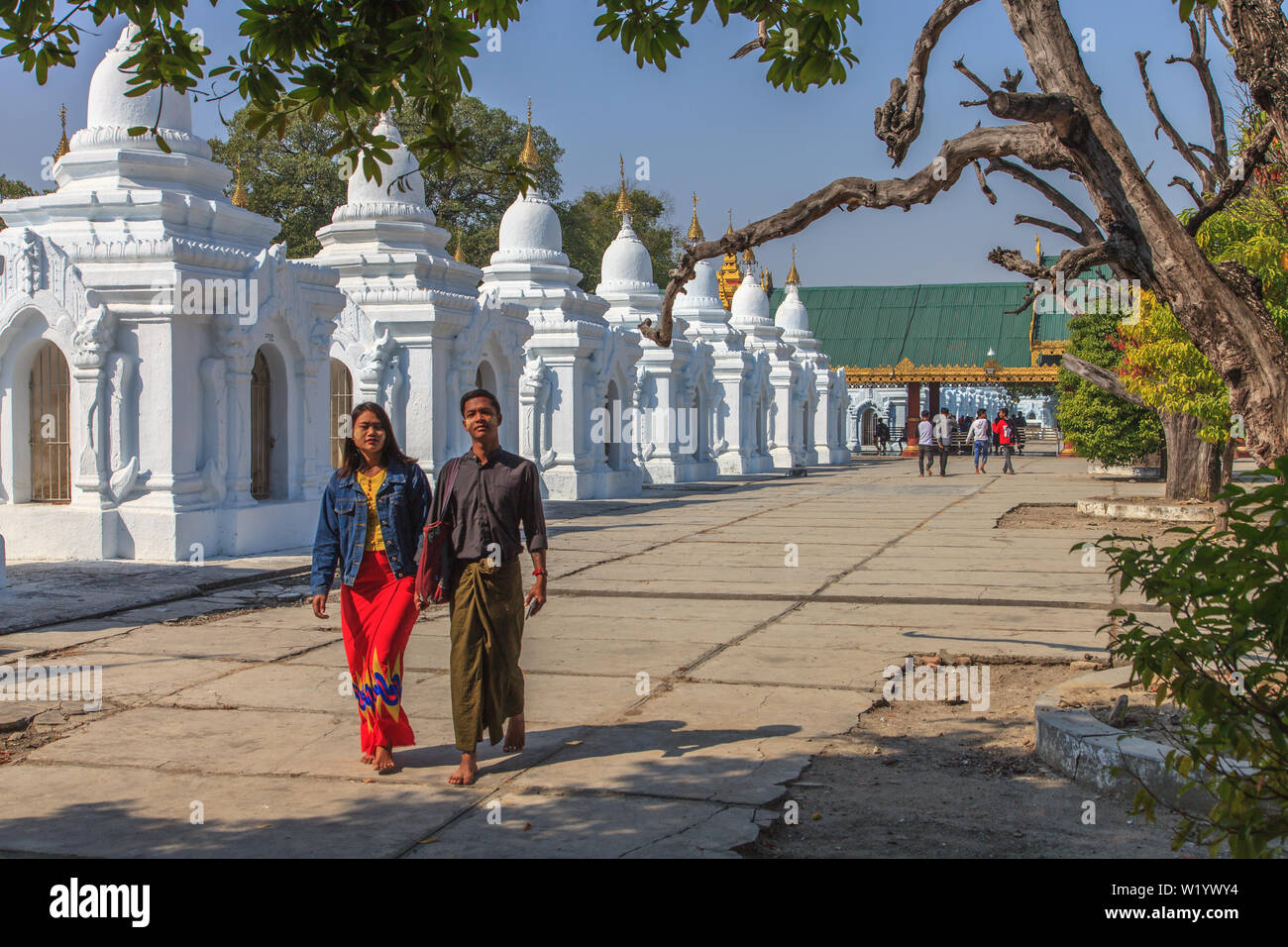 Una giovane coppia a piedi all'interno della pagoda Kuthodaw in Mandalay Foto Stock