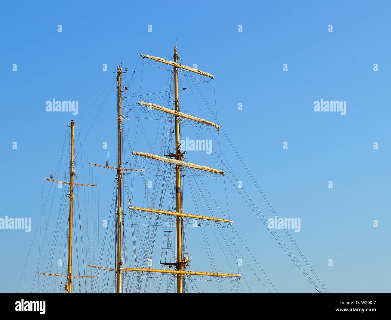 Tre alberi di una nave a vela con ripiegato vele e protezioni contro un cielo estivo blu, copia dello spazio. Foto Stock