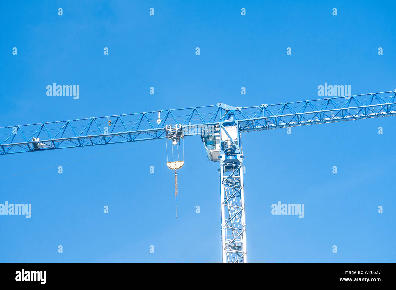 Alto edificio di gru a torre closeup sul cielo blu sullo sfondo Foto Stock