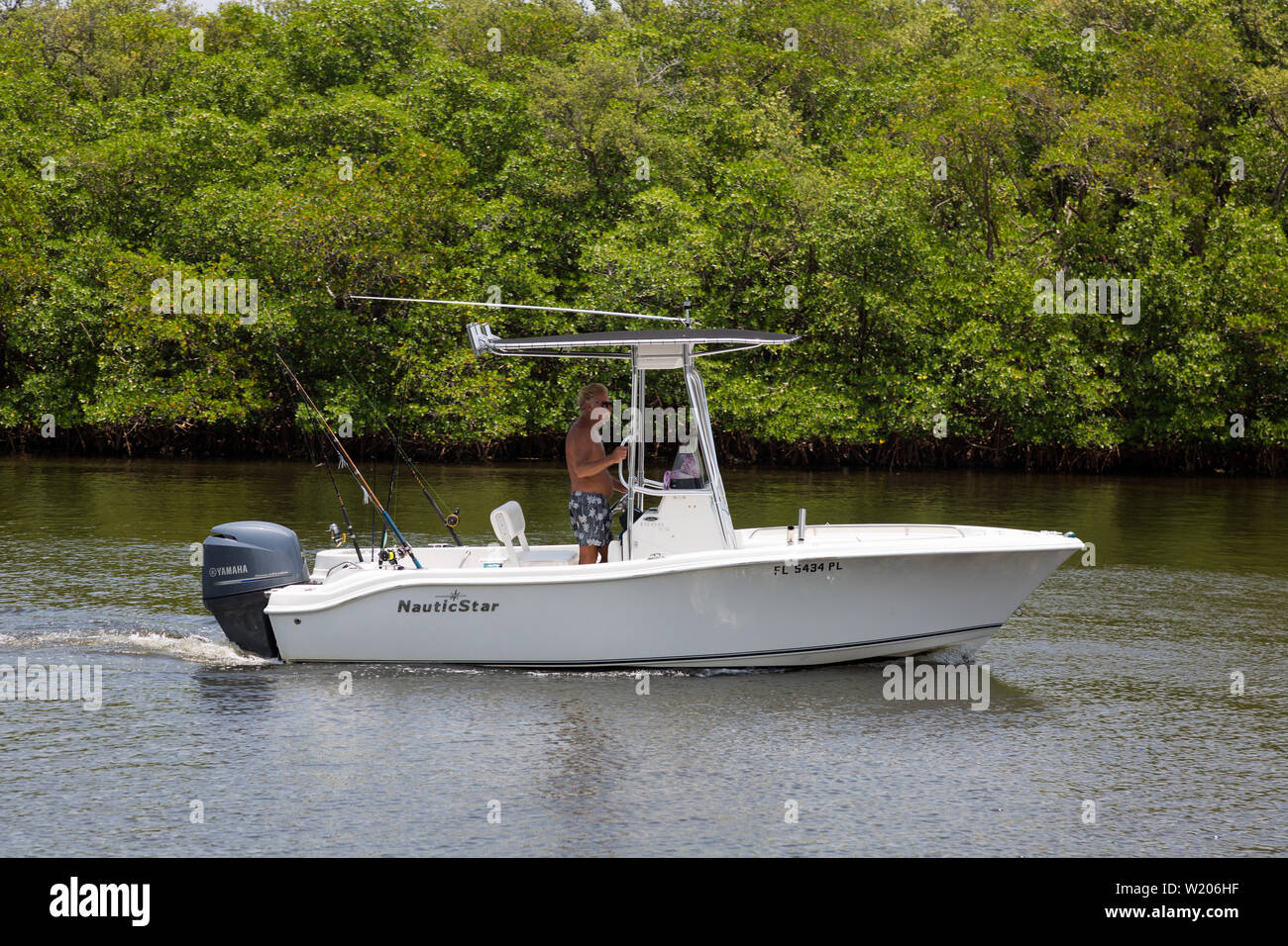 Un pescatore pilota la sua barca da pesca NauticStar attraverso le calme acque dell'Intercoastal Waterway tra Boynton Beach e Ocean Ridge, Florida, Stati Uniti Foto Stock