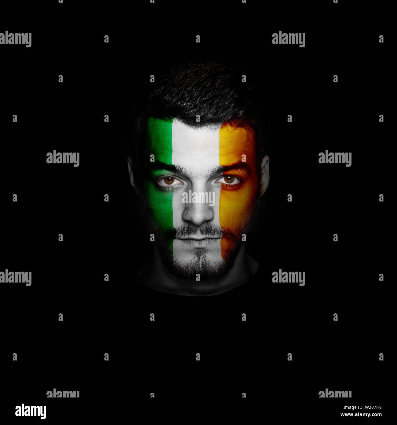 Bandiera dell'Irlanda dipinta su una faccia di un uomo. Foto Stock