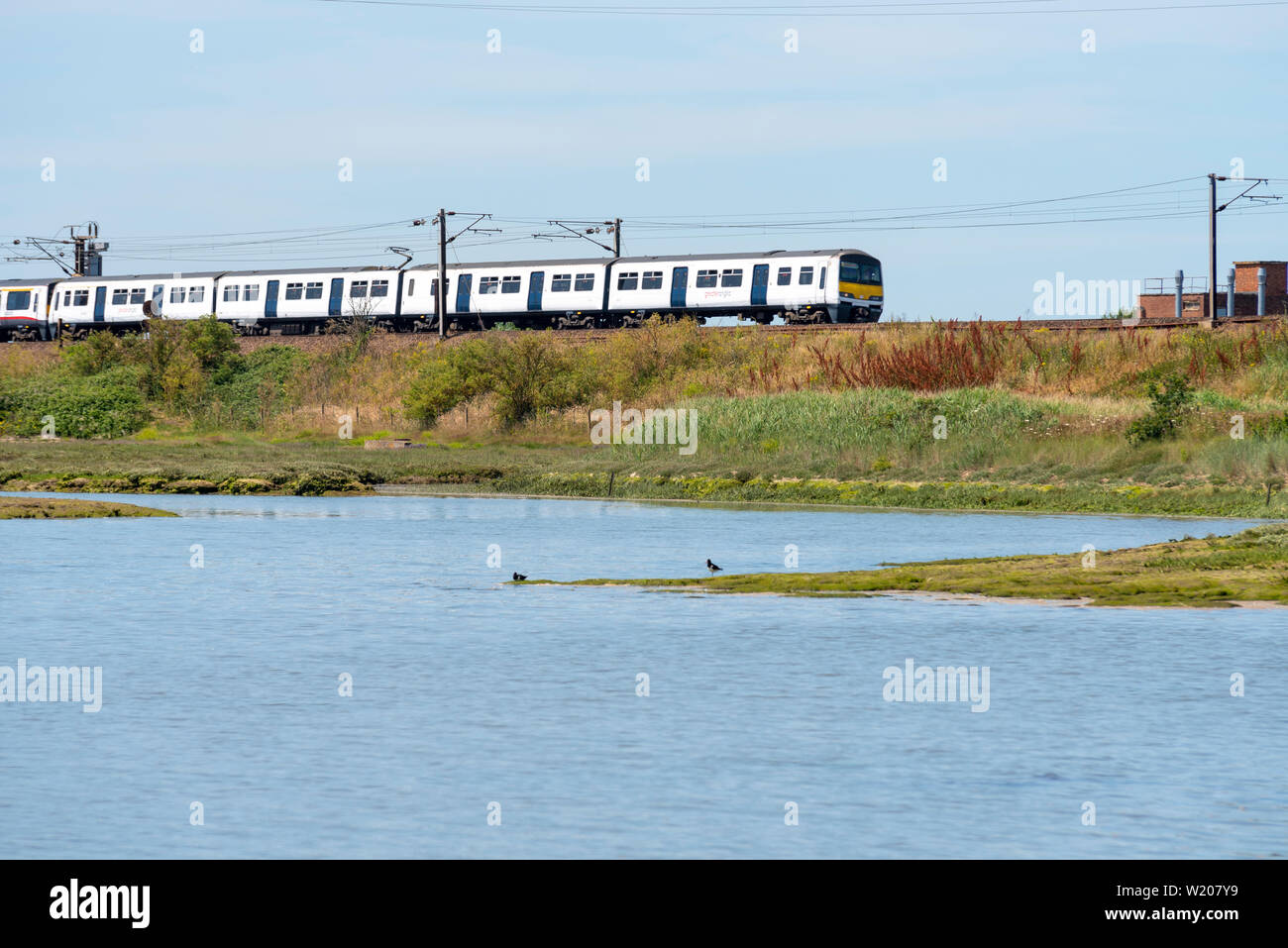 La British Rail Class 321 la corrente alternata (CA) Electric Multiple Unit treno EMU sulla costa est la linea di maggiore Anglia stazione ferroviaria nei pressi di Manningtree Foto Stock