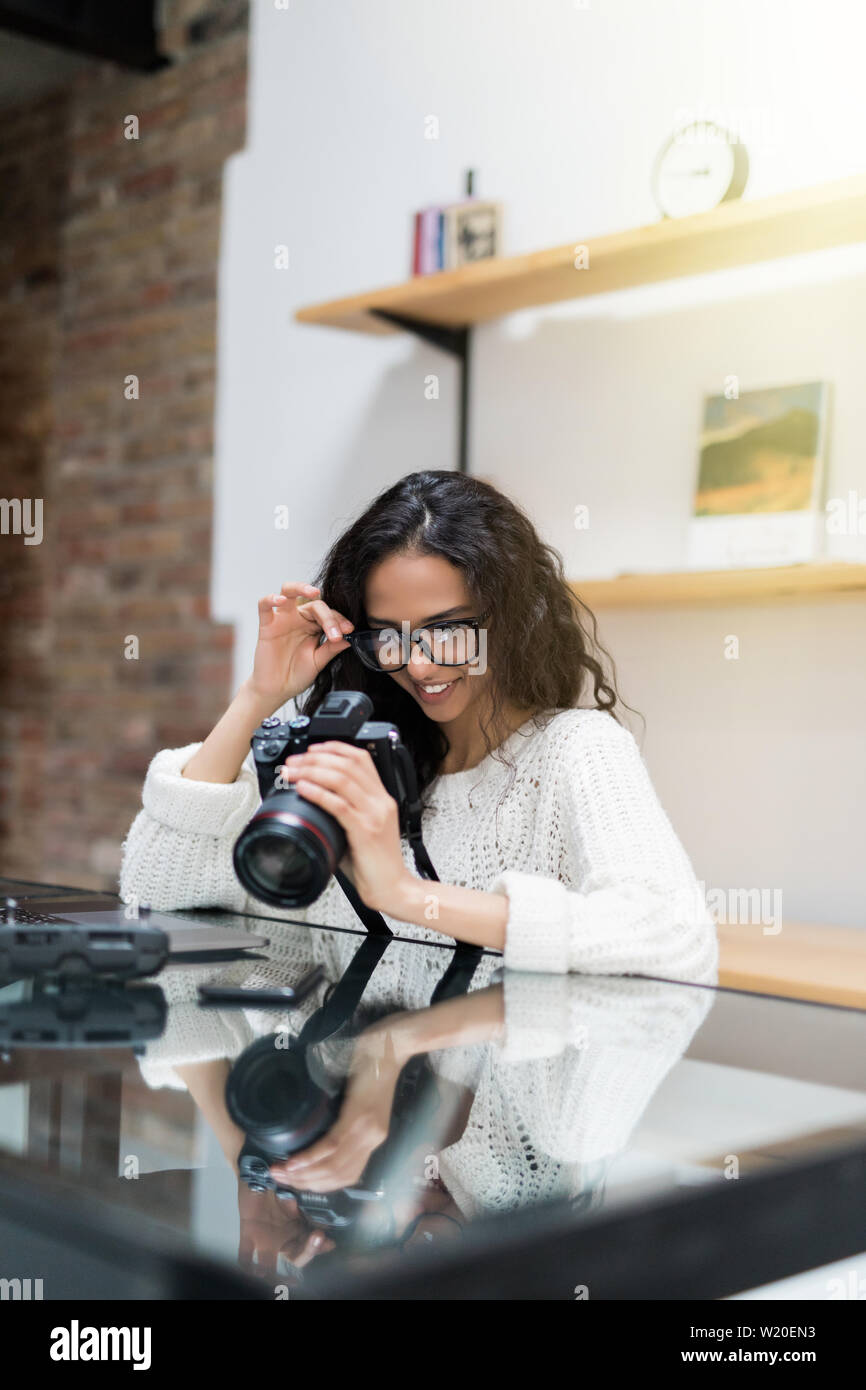 Fotografo femmina seduti alla scrivania con il computer portatile Foto Stock