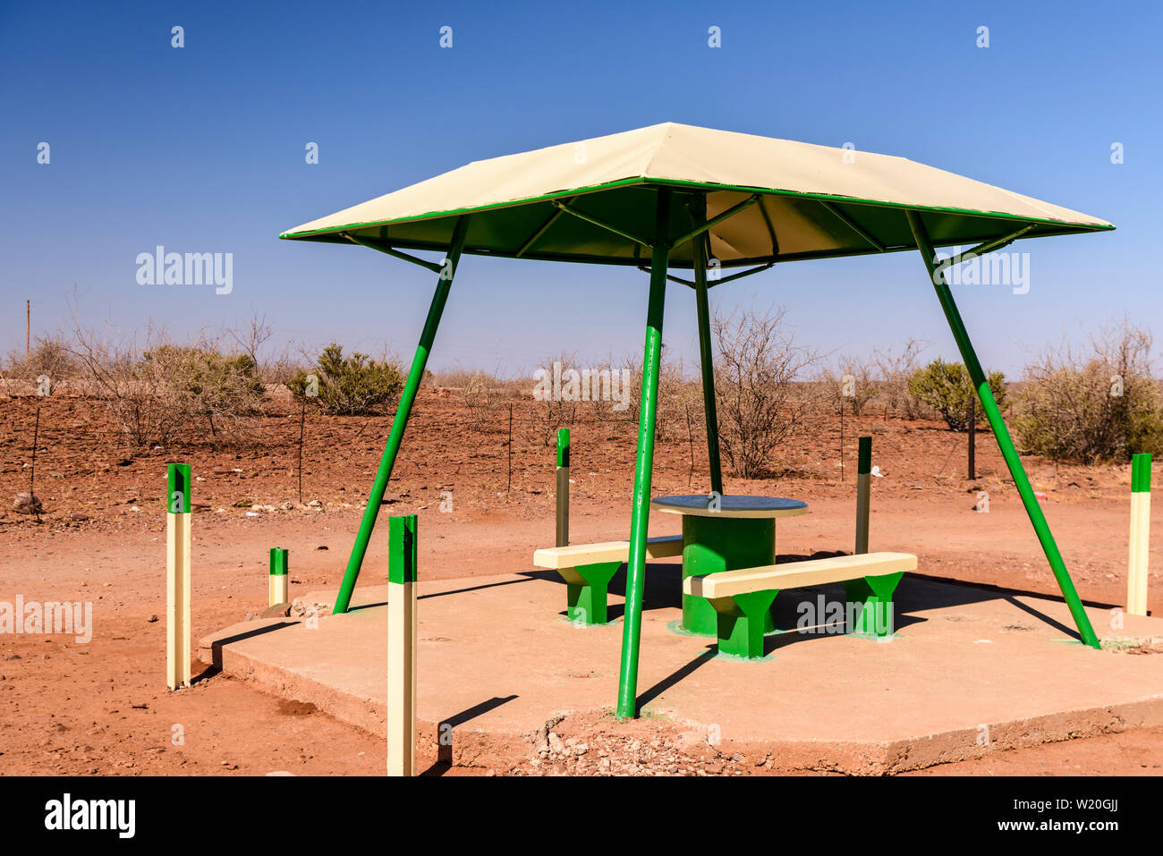 Picnic in calcestruzzo di tavolo e panche con una tettoia per ombra, tipicamente collocato ogni 10-20km lungo le strade in Namibia Foto Stock