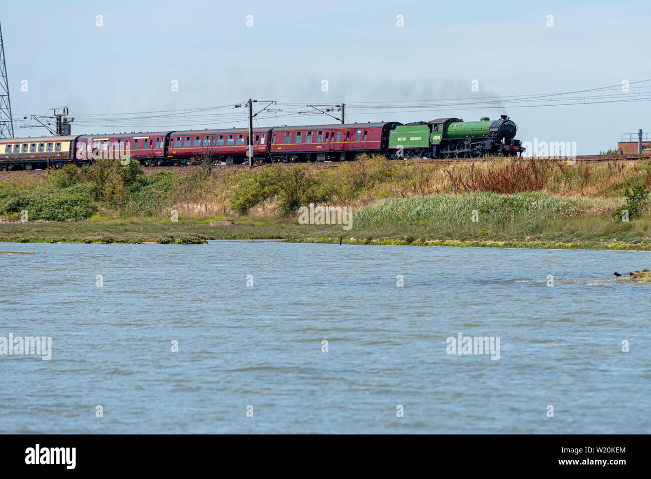 61306 BR B1 classe 'Mayflower'arrampicata un terrapieno sopra il fiume Stour in Manningtree, Essex. Sogni di vapore ferrovia Co. speciale sulla maggiore Anglia rotaie Foto Stock
